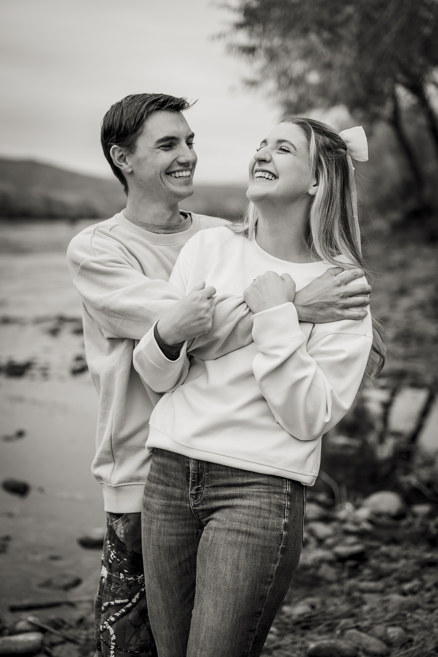 Black and white photo of couple hugging and sharing in laughter