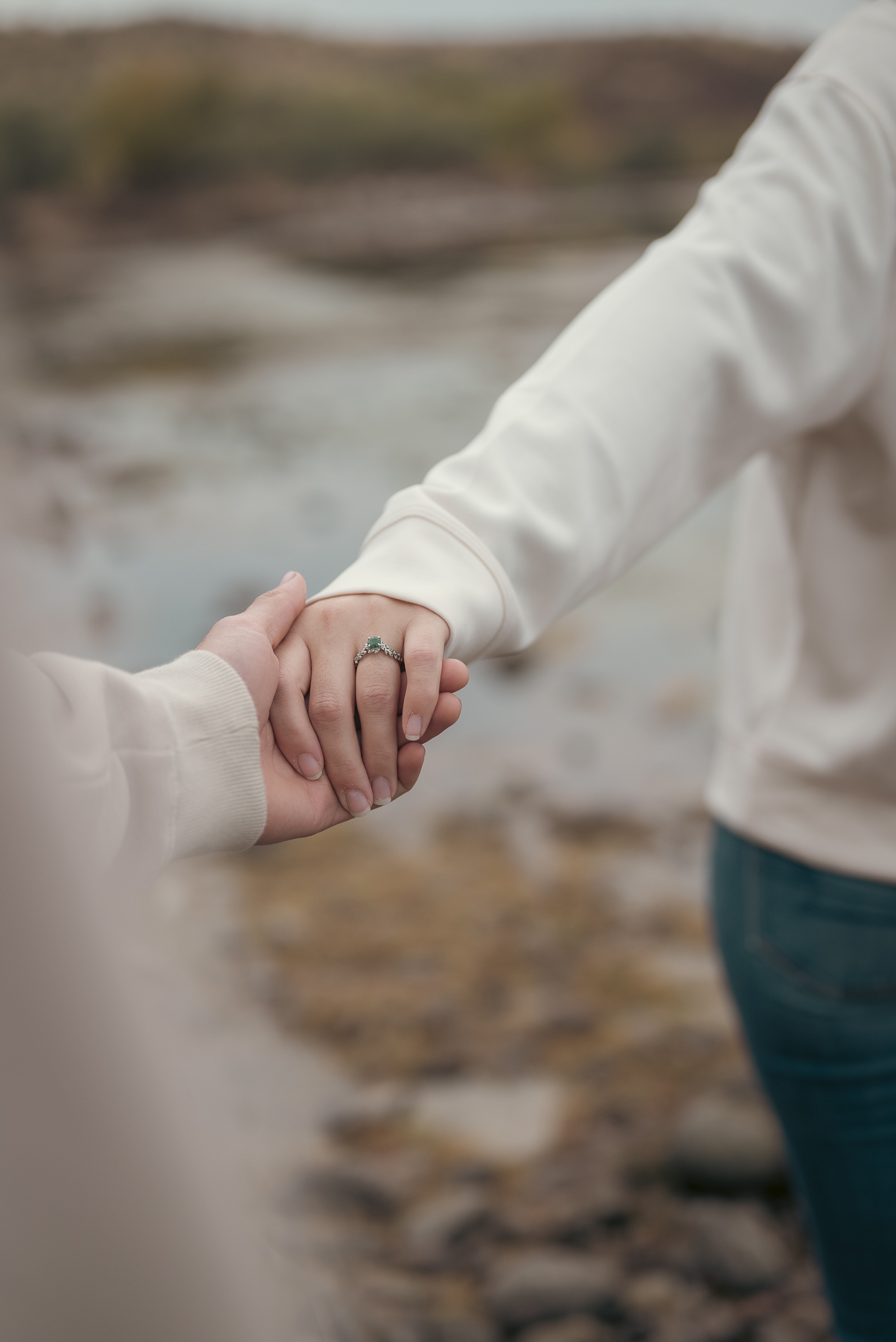 Engaged couple's hands held together showing engagement ring