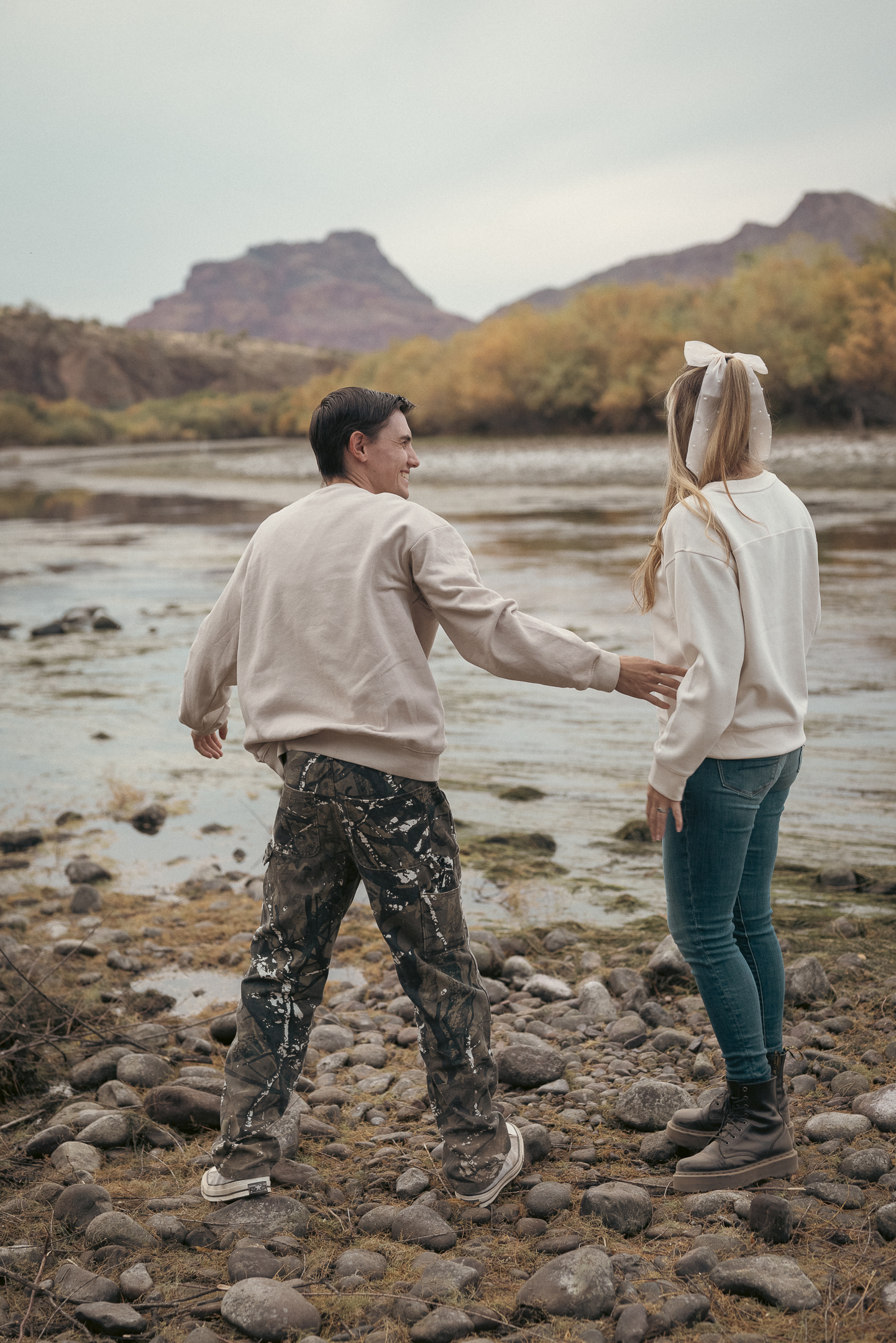 Couple looking out onto Lower Salt River with desert cliffs in the backdrop