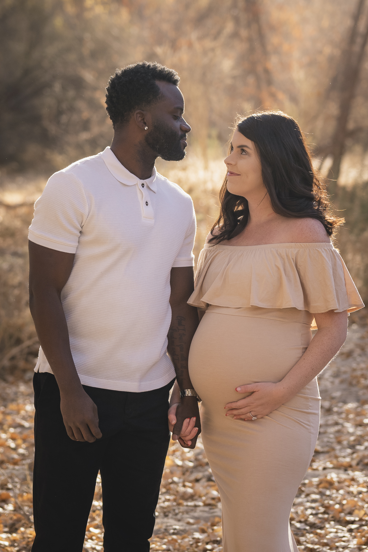 Couple in nature setting holding hands during maternity photo session at Hassayampa River Preserve