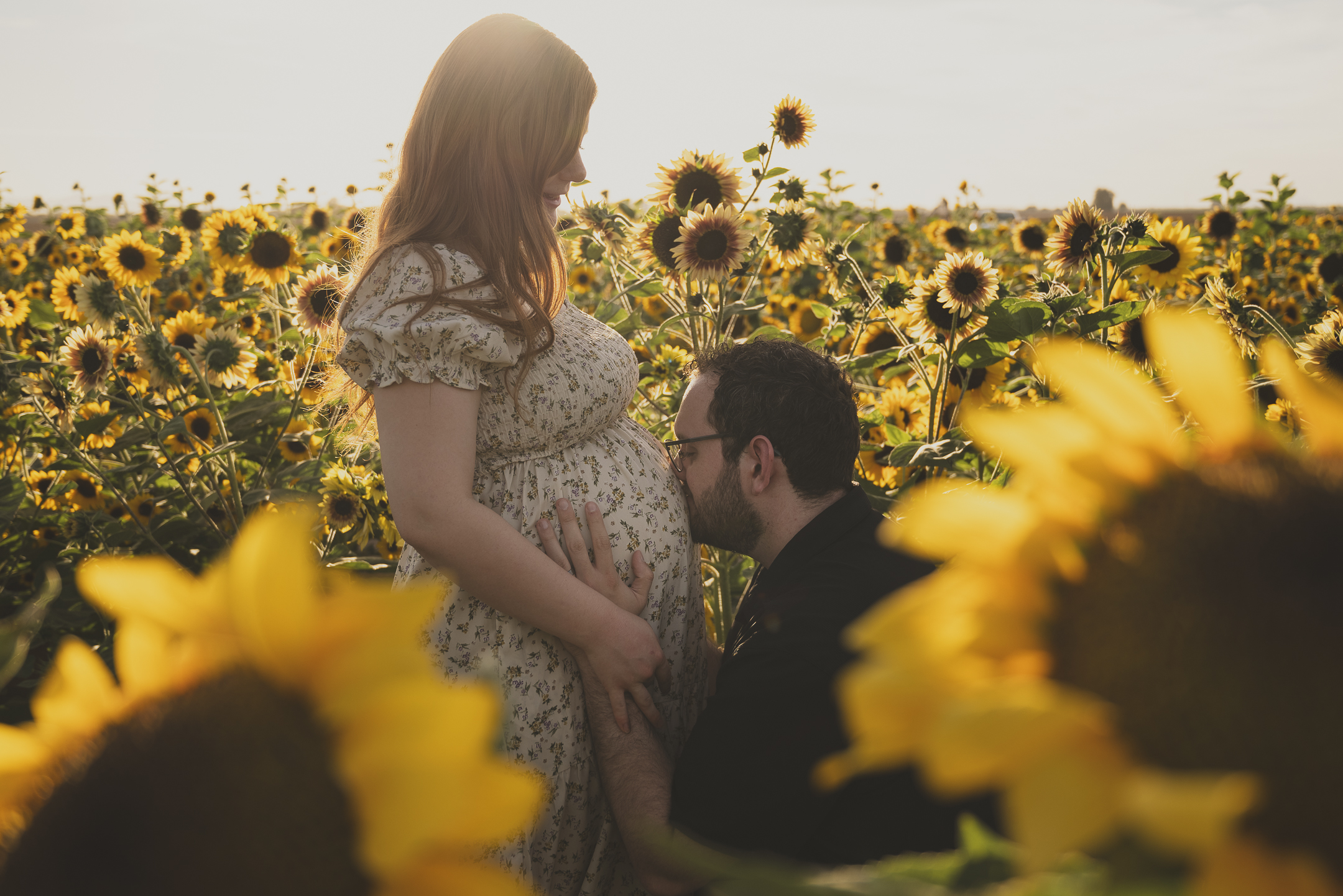 Maternity couple kissing in a sunflower field, Arizona