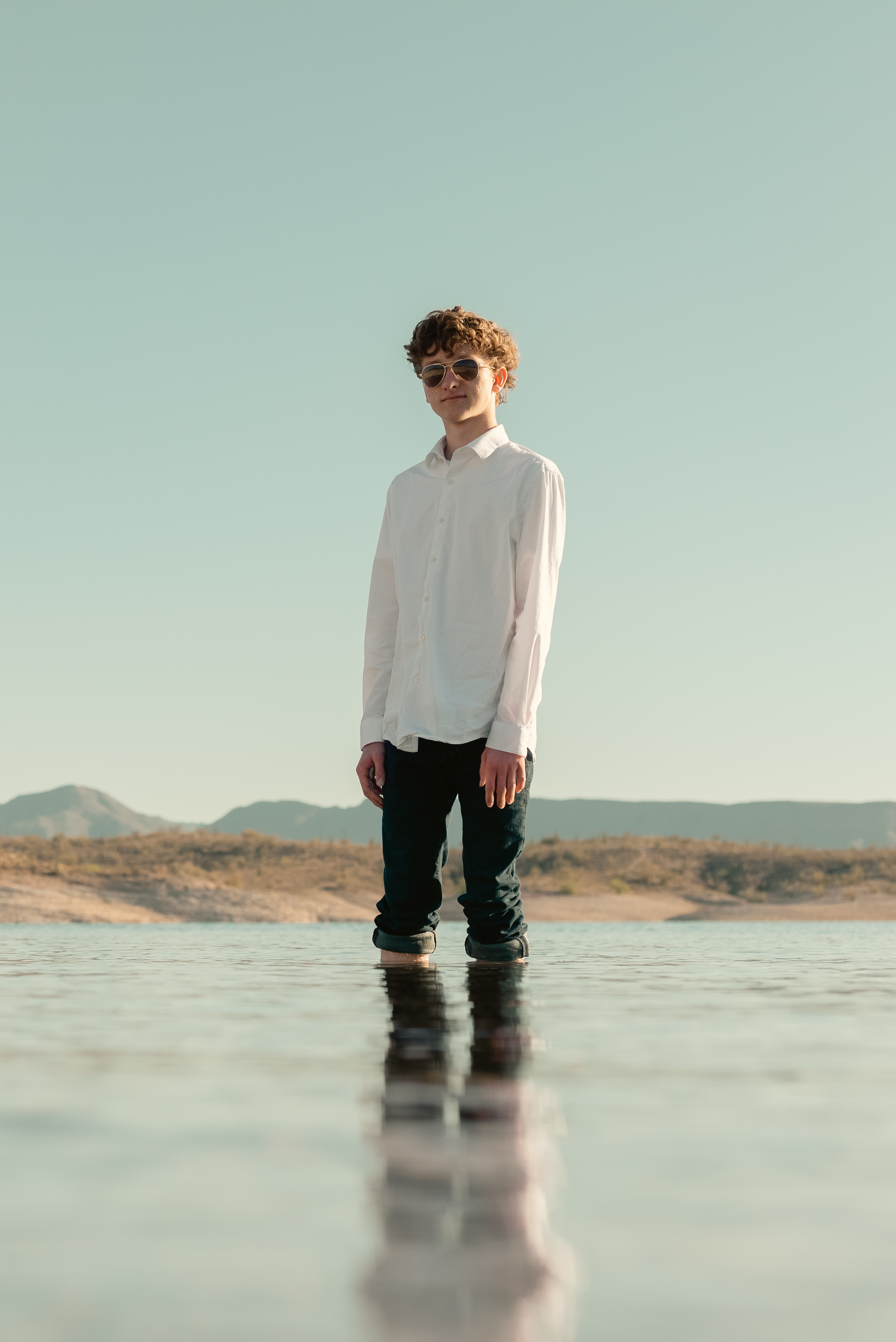 Senior portrait of young man standing in water at Lake Pleasant Arizona.