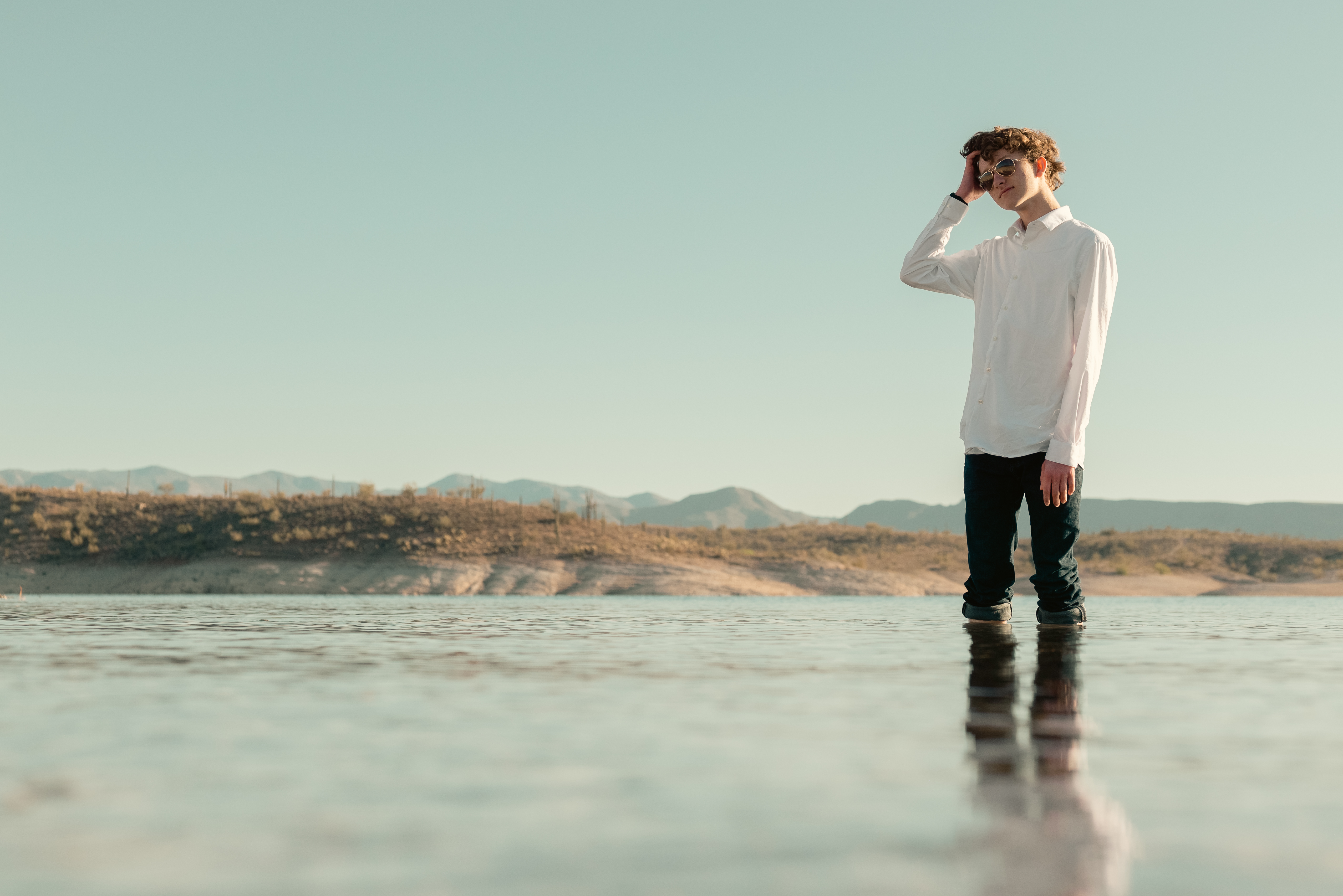 Senior portrait of young man standing in water at Lake Pleasant Arizona.
