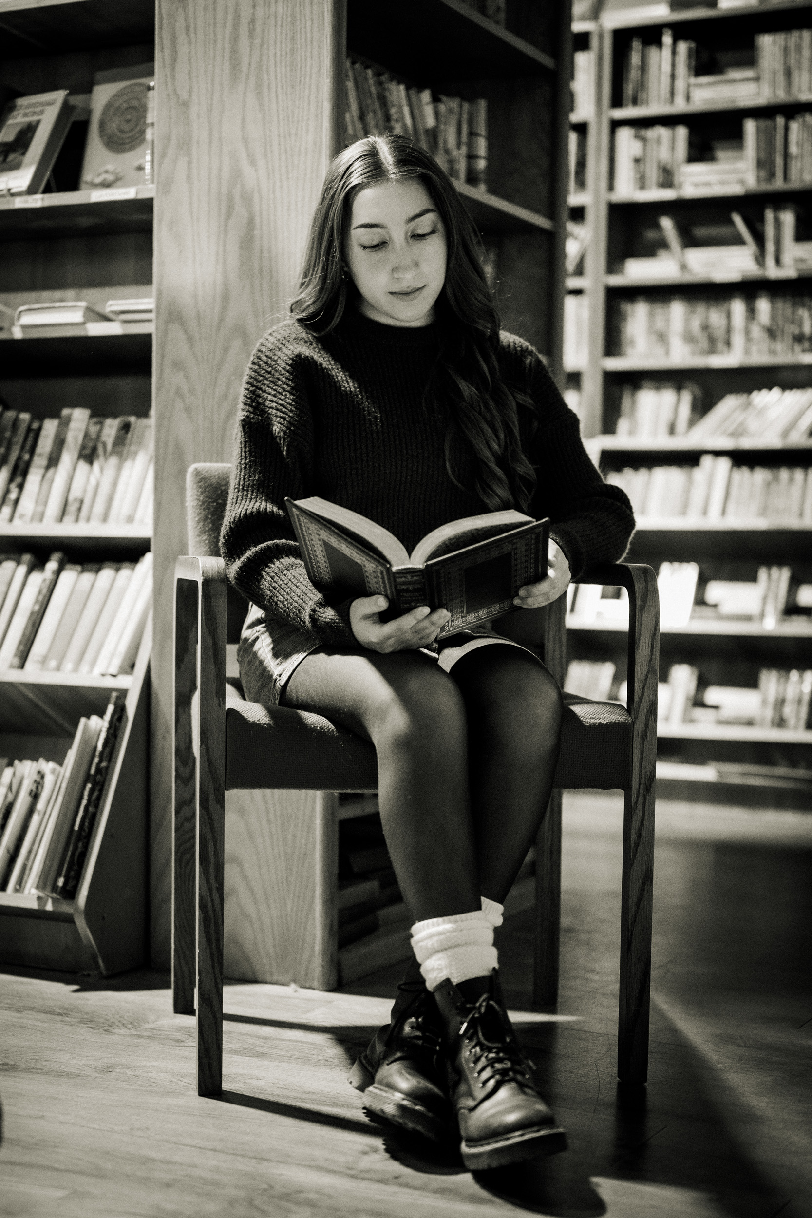 Girl sitting reading books in the Phoenix Book Gallery store.