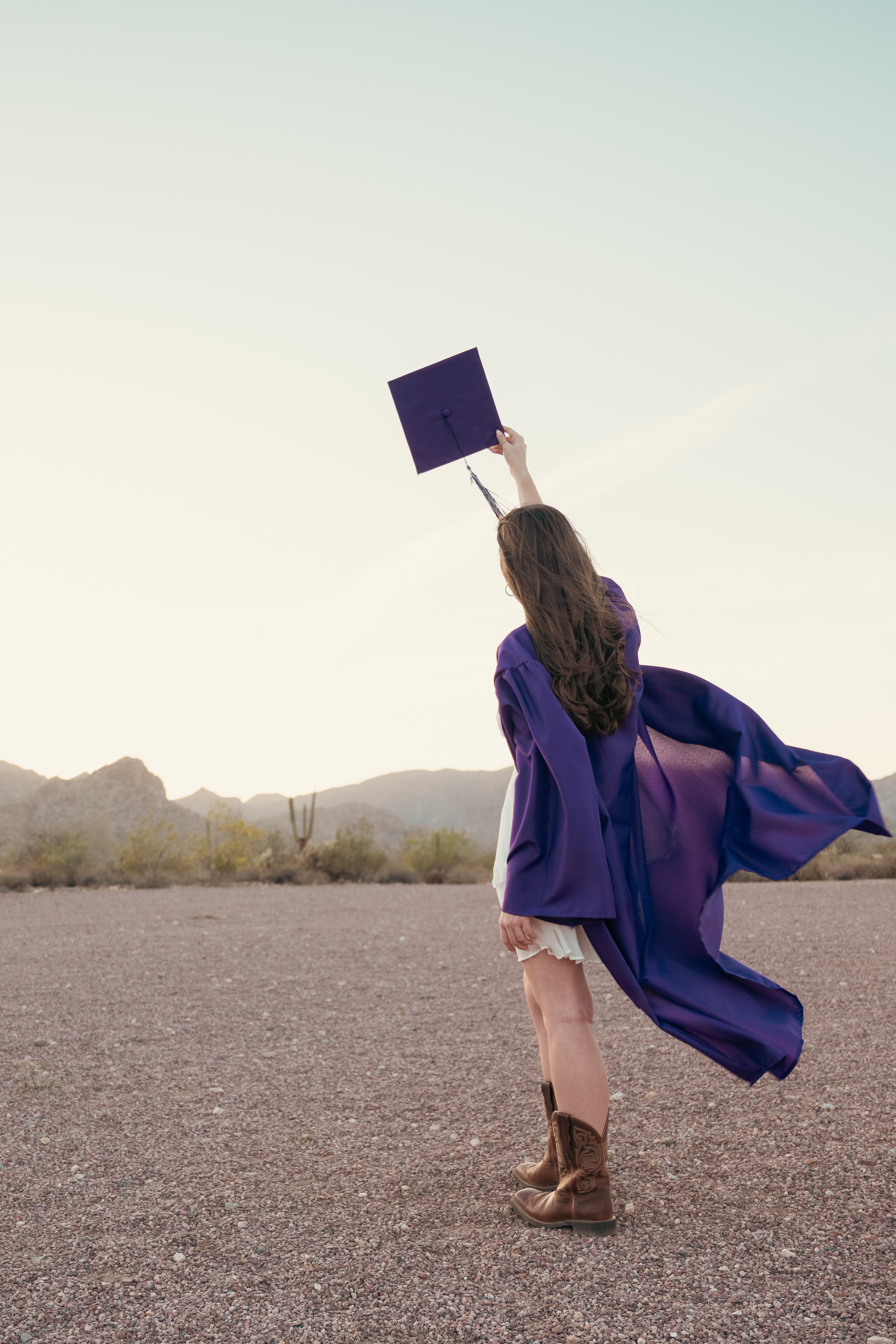 Senior portrait with cap and gown in the desert at  White Tank Mountains in Surprise Arizona