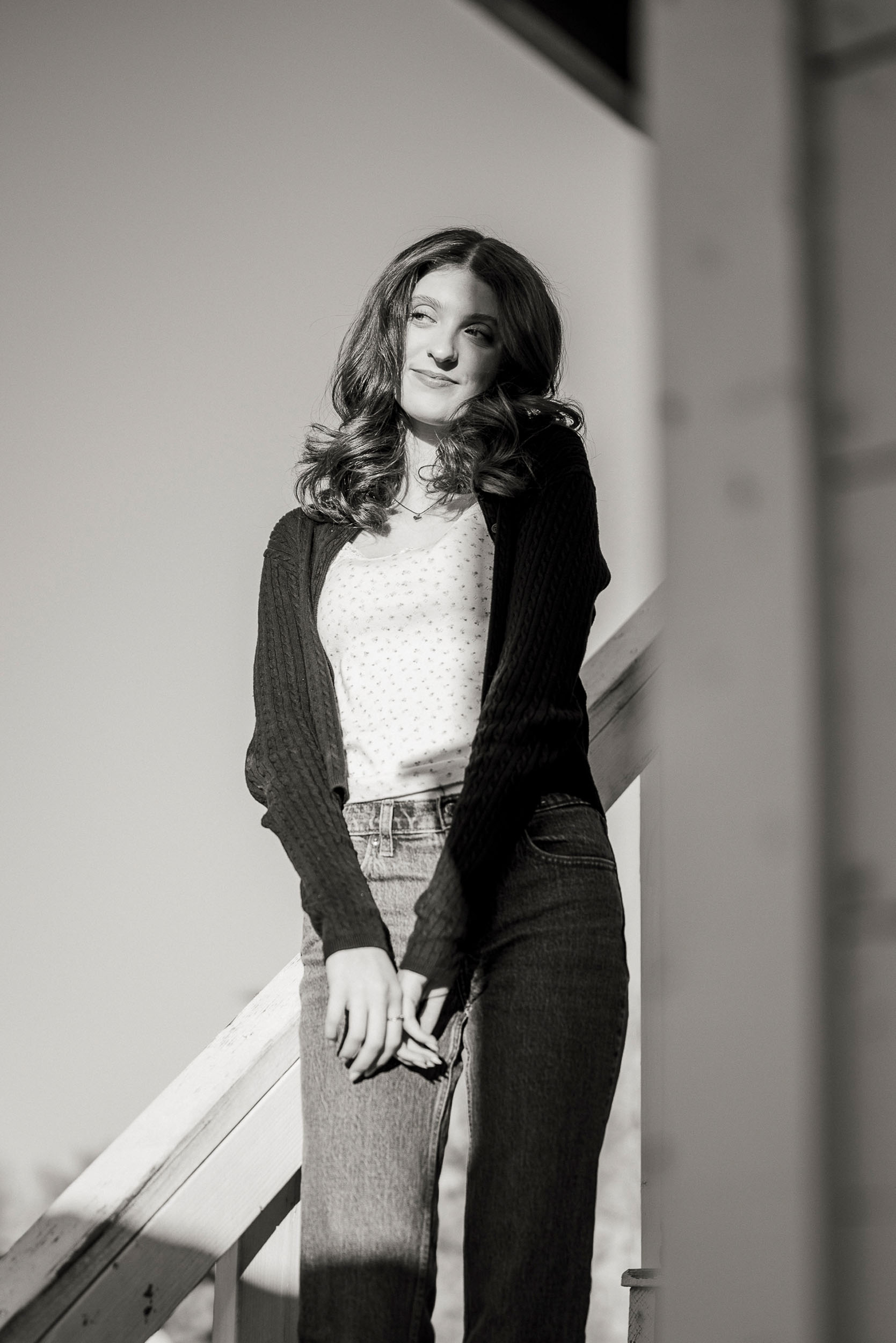 Senior photo of young woman taken on stairs of farm house in Sahuaro Ranch Park in Glendale, AZ.