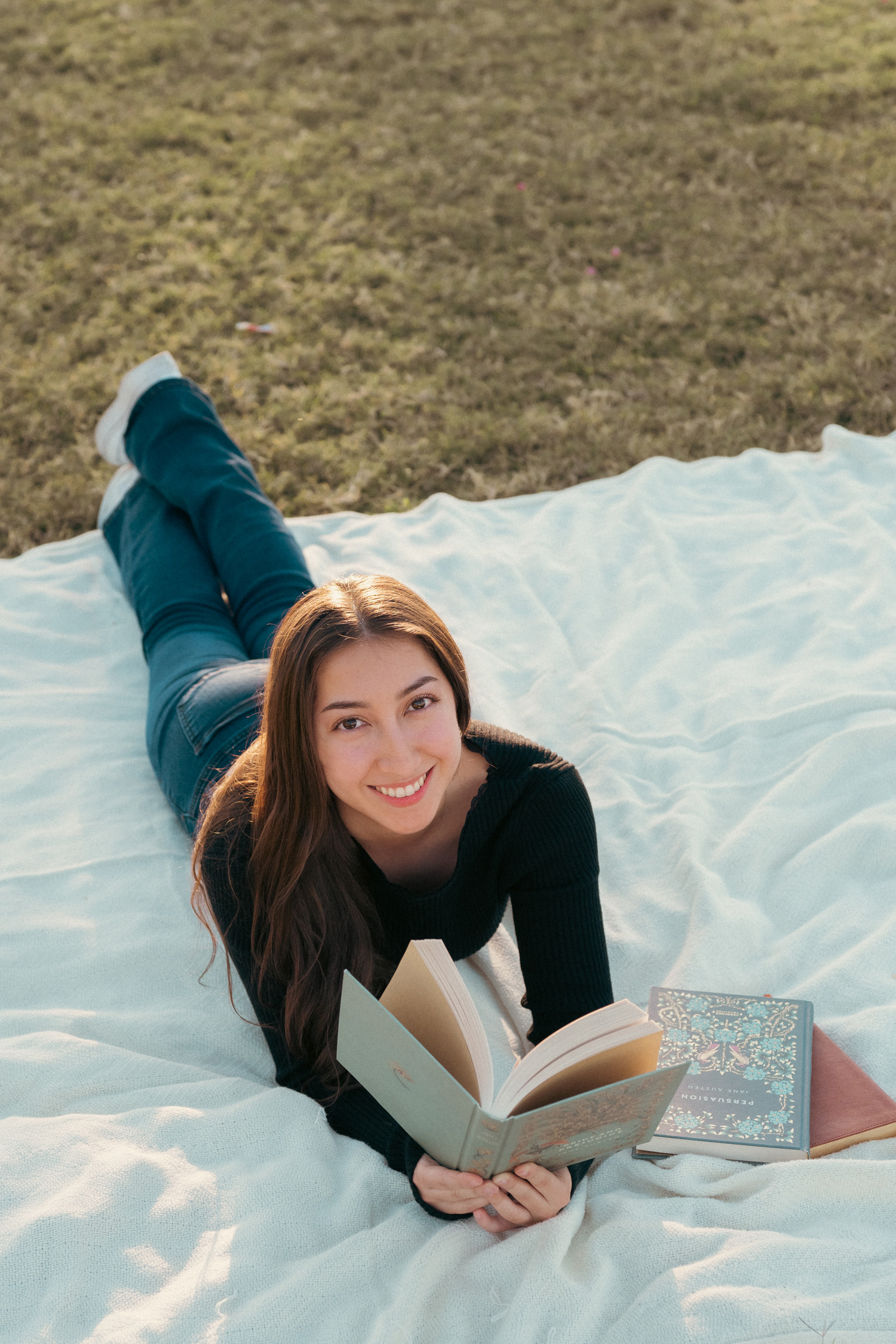 Girl laying on blanket reading at Sahuaro Ranch Park Glendale Arizona.