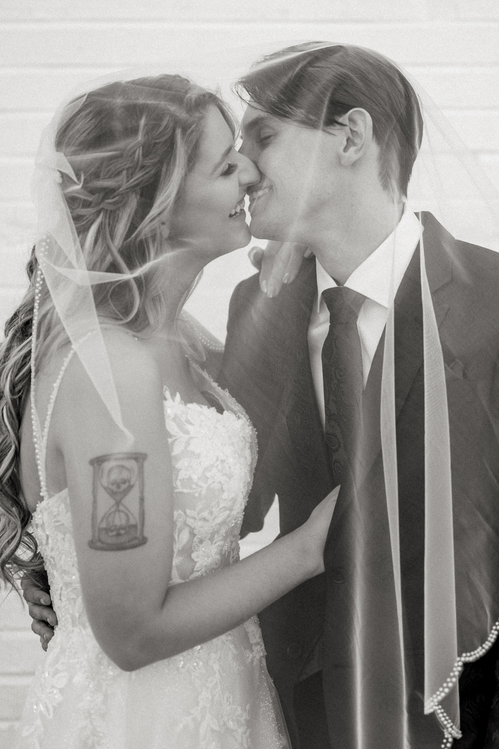 bride and groom kissing framed by wedding veil.