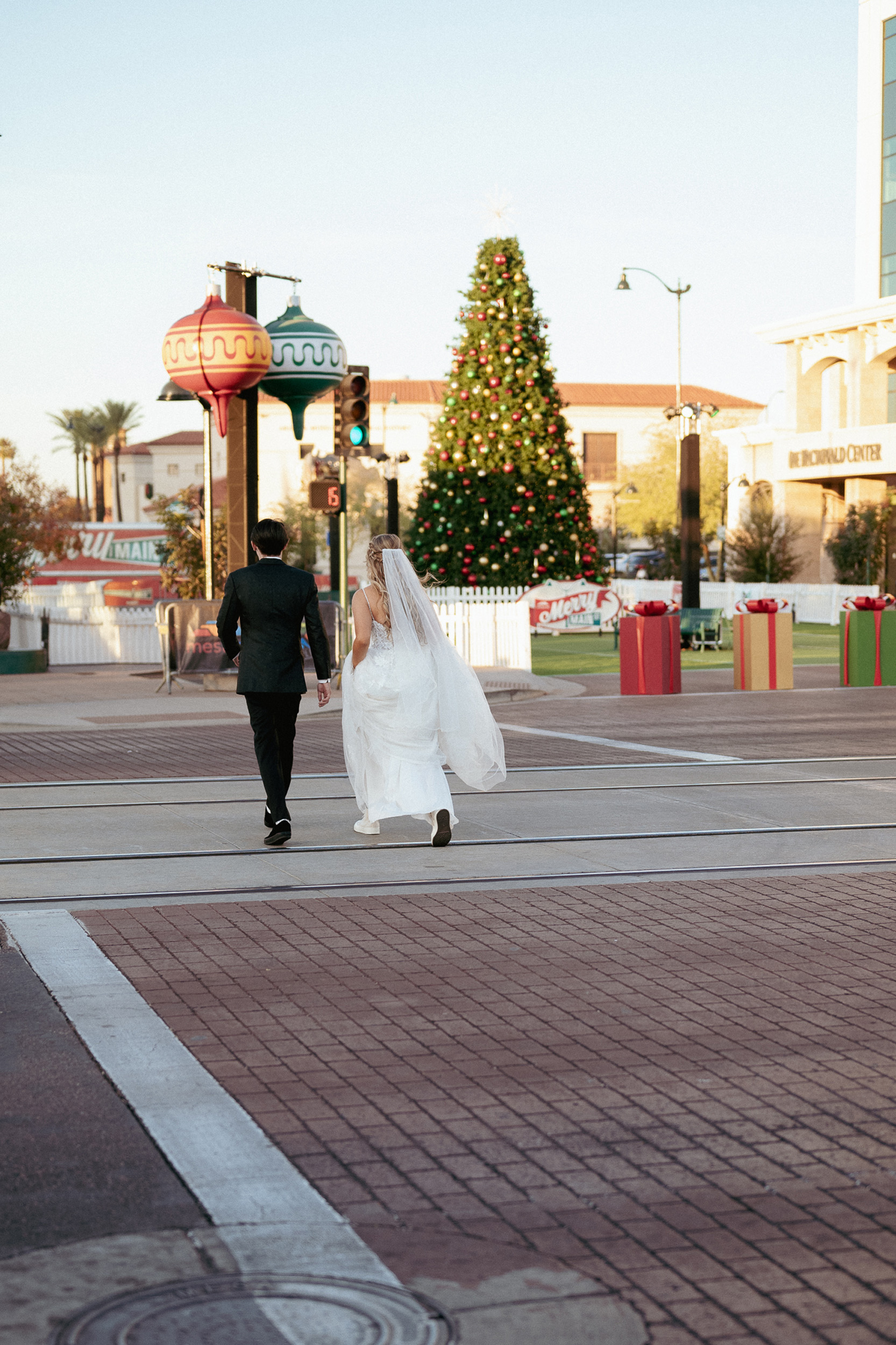 Bride and Groom Mesa, Arizona Main St. Tre Bella crossing street holding hands.