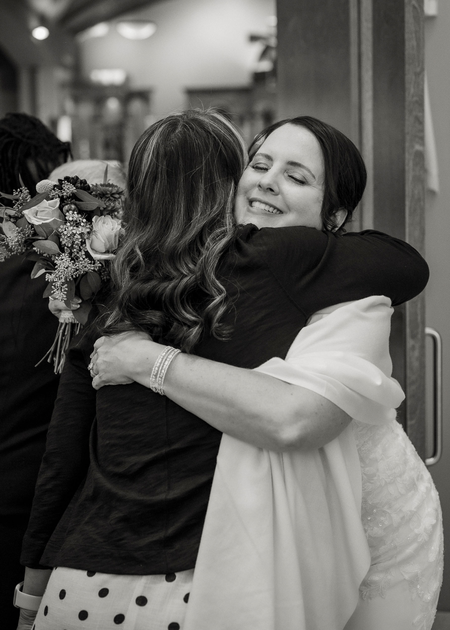 Bride hugging guest at wedding at St. Clare of Assisi catholic church Surprise, AZ