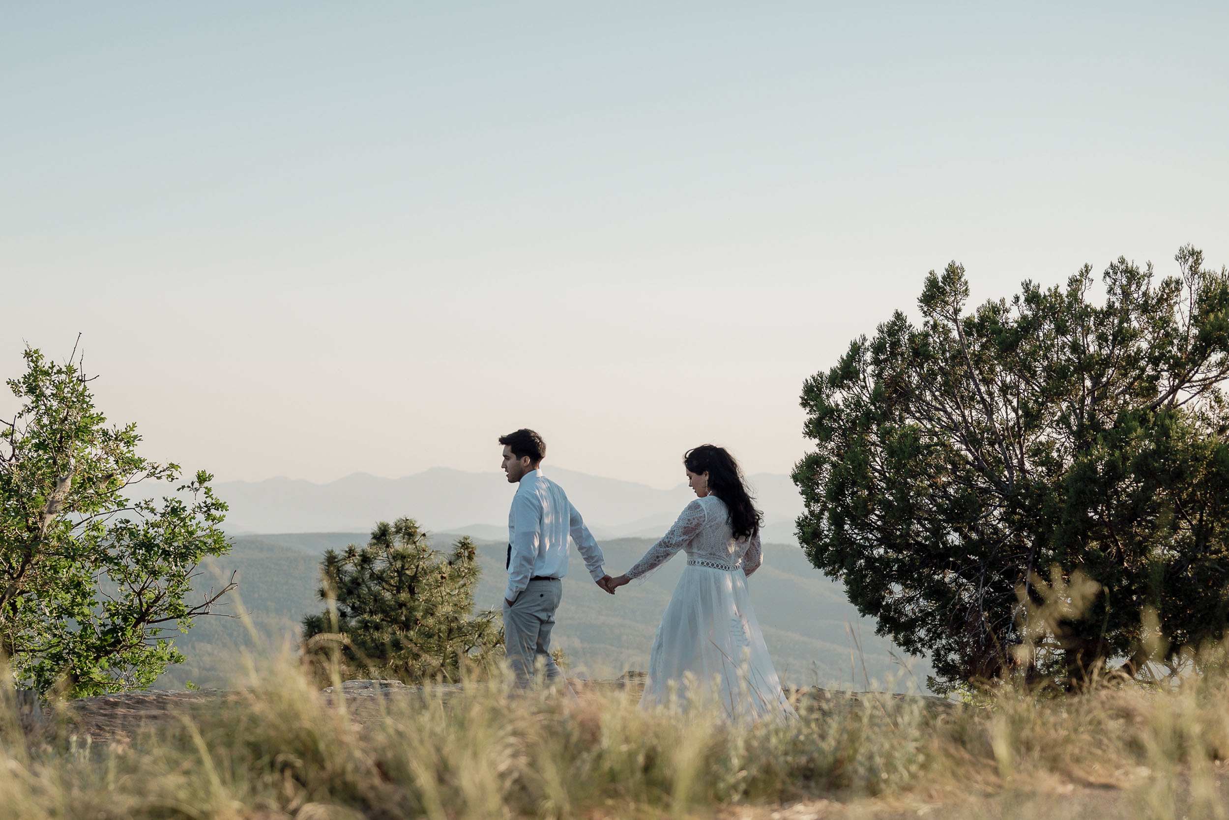 Bride and groom walking along rim during elopement wedding at the Mogollon Rim in Payson, Arizona