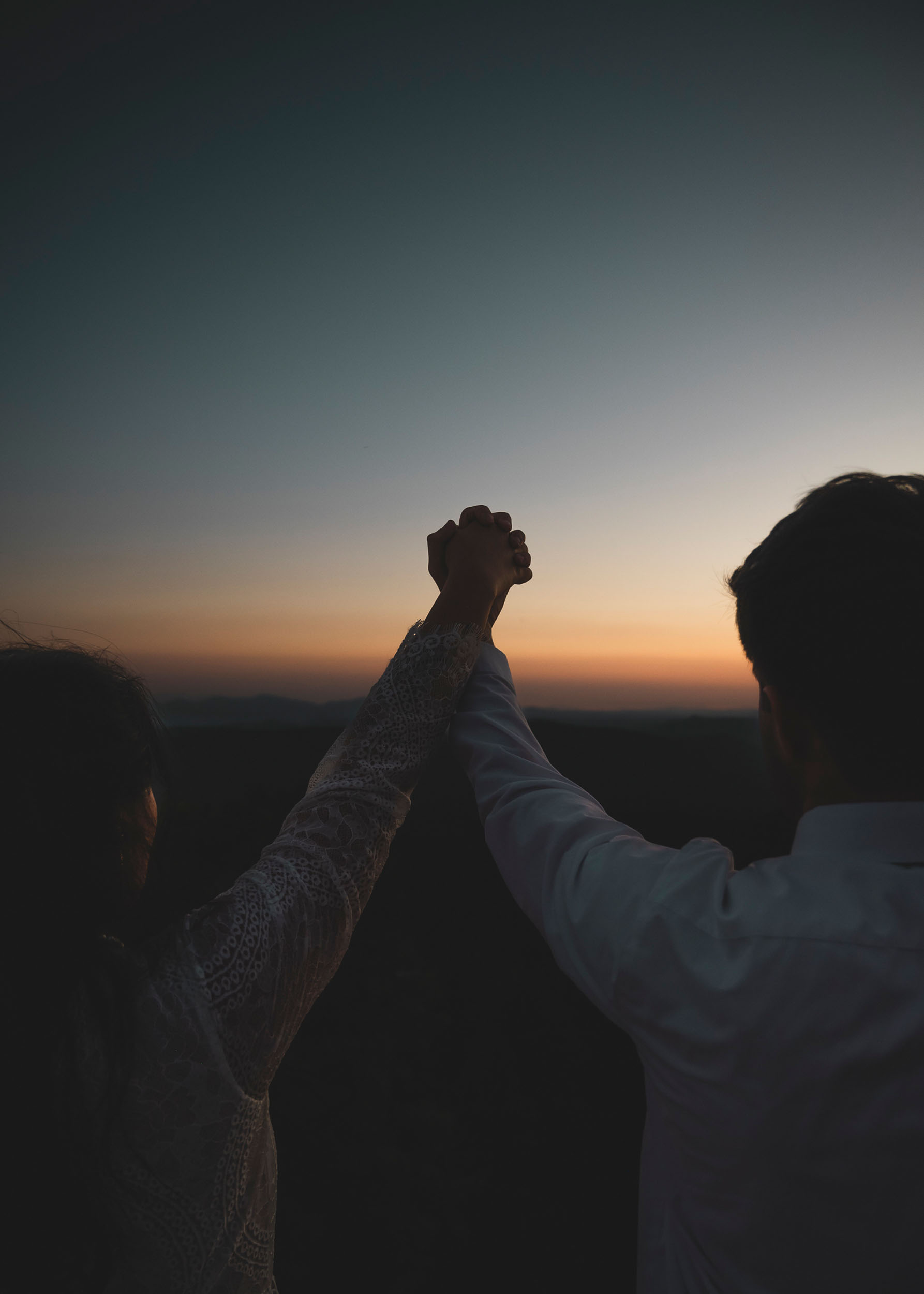 Bride and groom joining hands at sunset during elopement wedding at the Mogollon Rim in Payson, Arizona