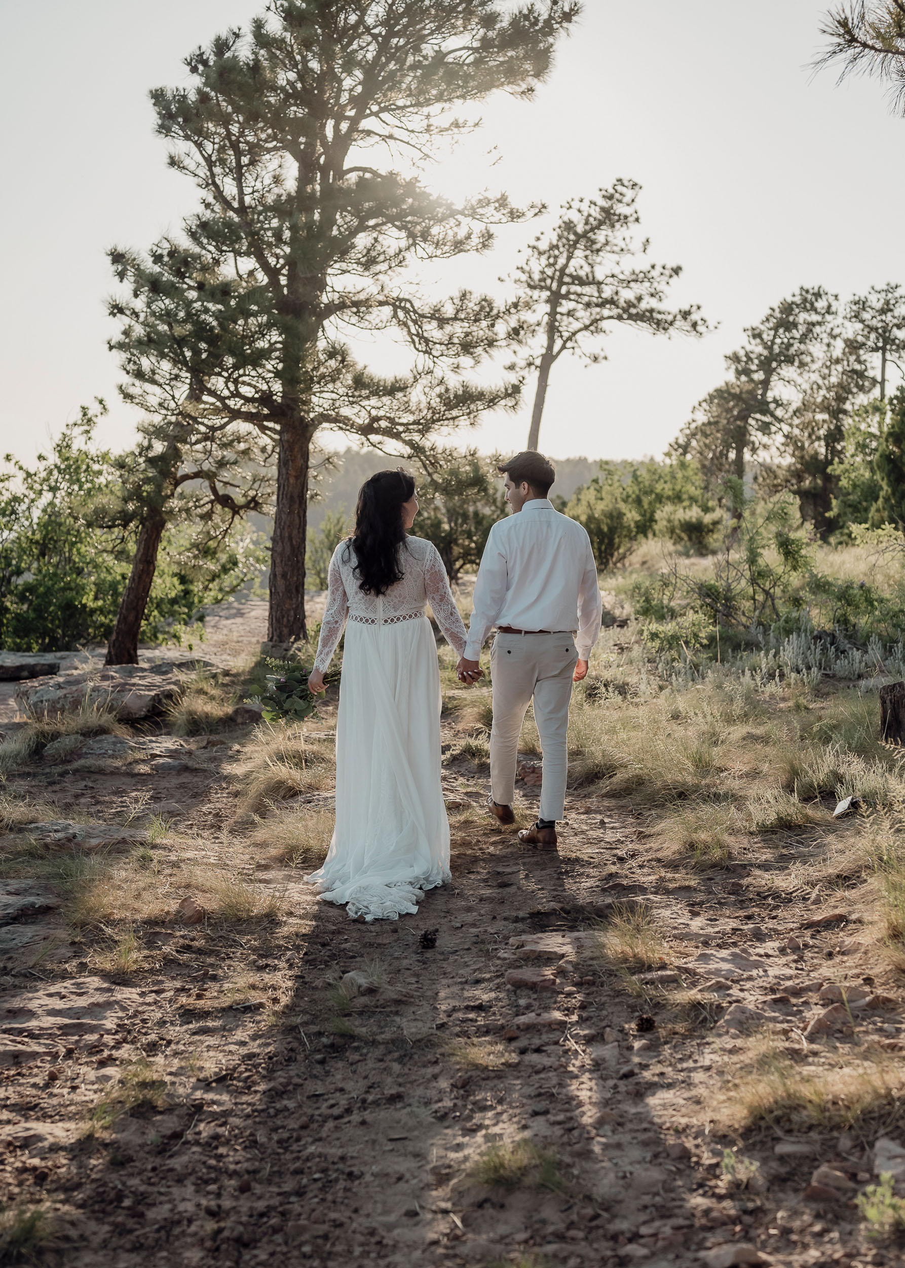 Bride and groom walk in nature during elopement wedding at the Mogollon Rim in Payson, Arizona