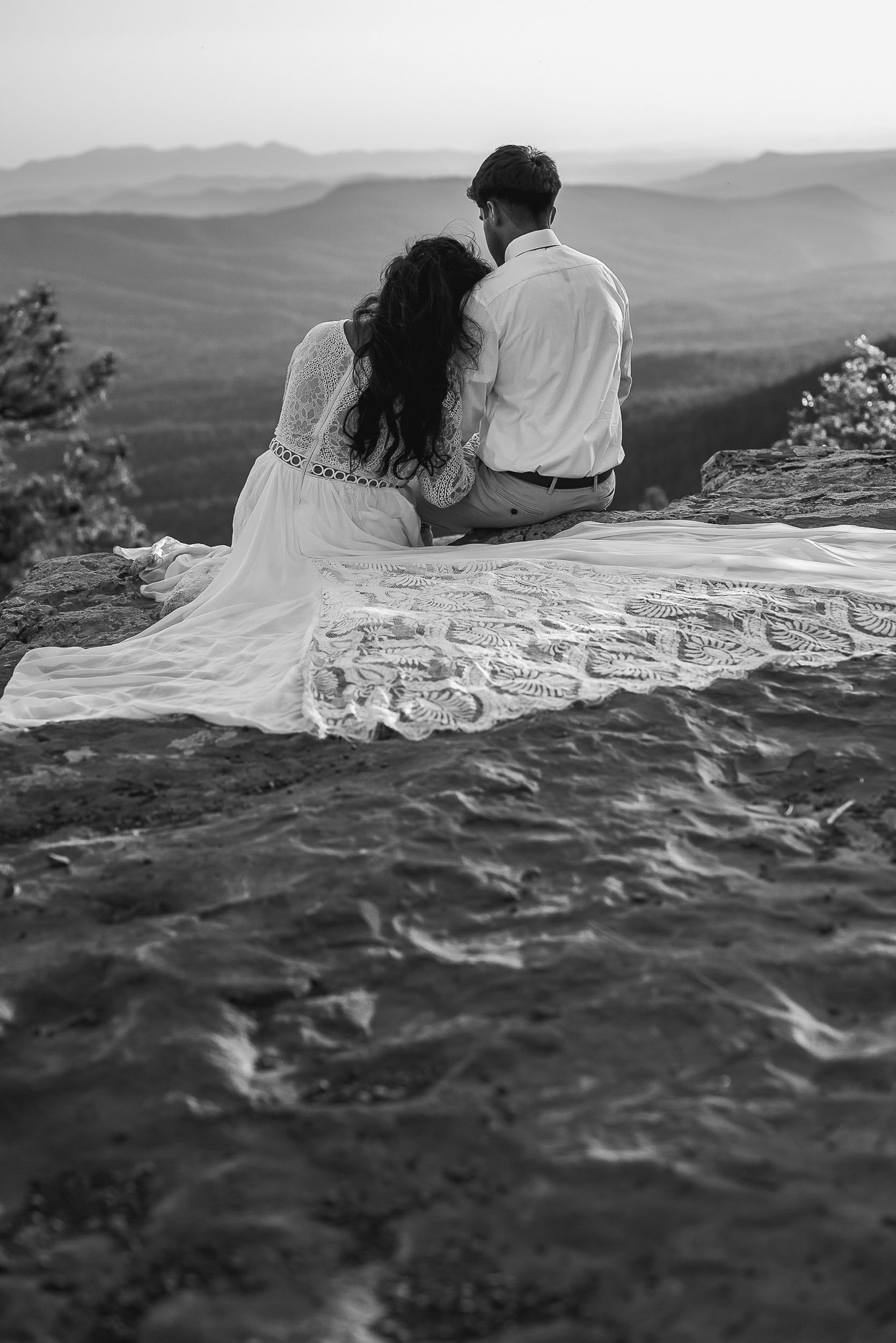 Bride and groom sitting cliffside during elopement wedding at the Mogollon Rim in Payson, Arizona