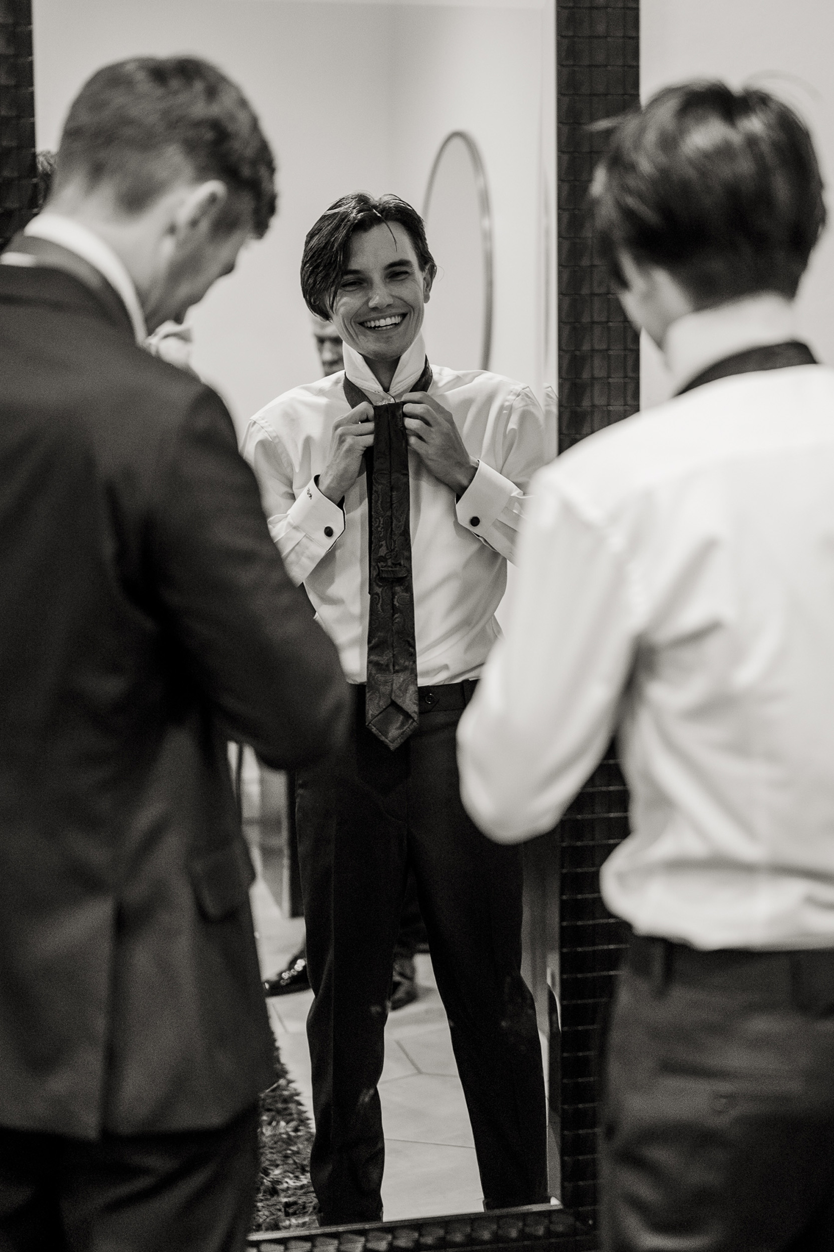Groom reflection in mirror getting ready for wedding day at Tre Bella Mesa Arizona.