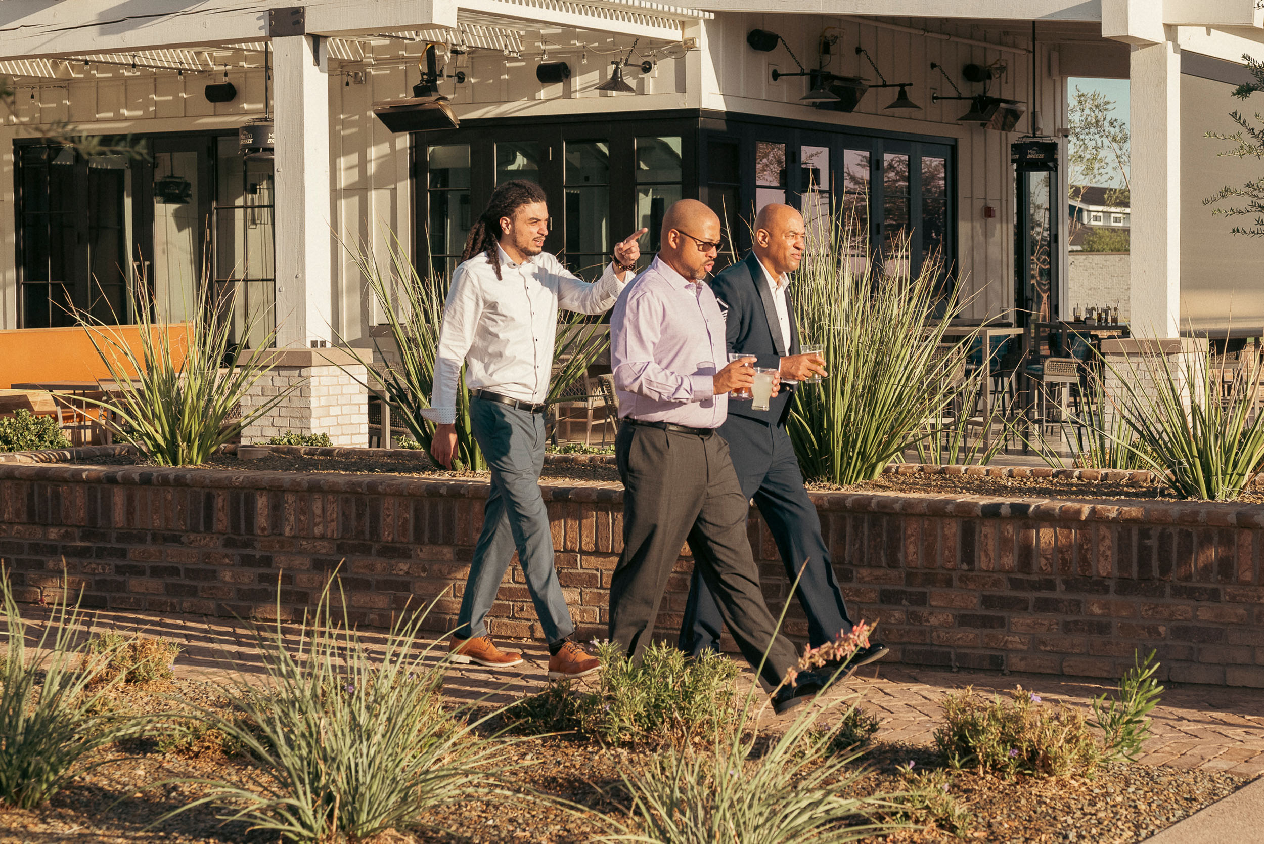 Groom and guests walking outside to venue grounds at Sterling Grove Copper + Rye wedding reception