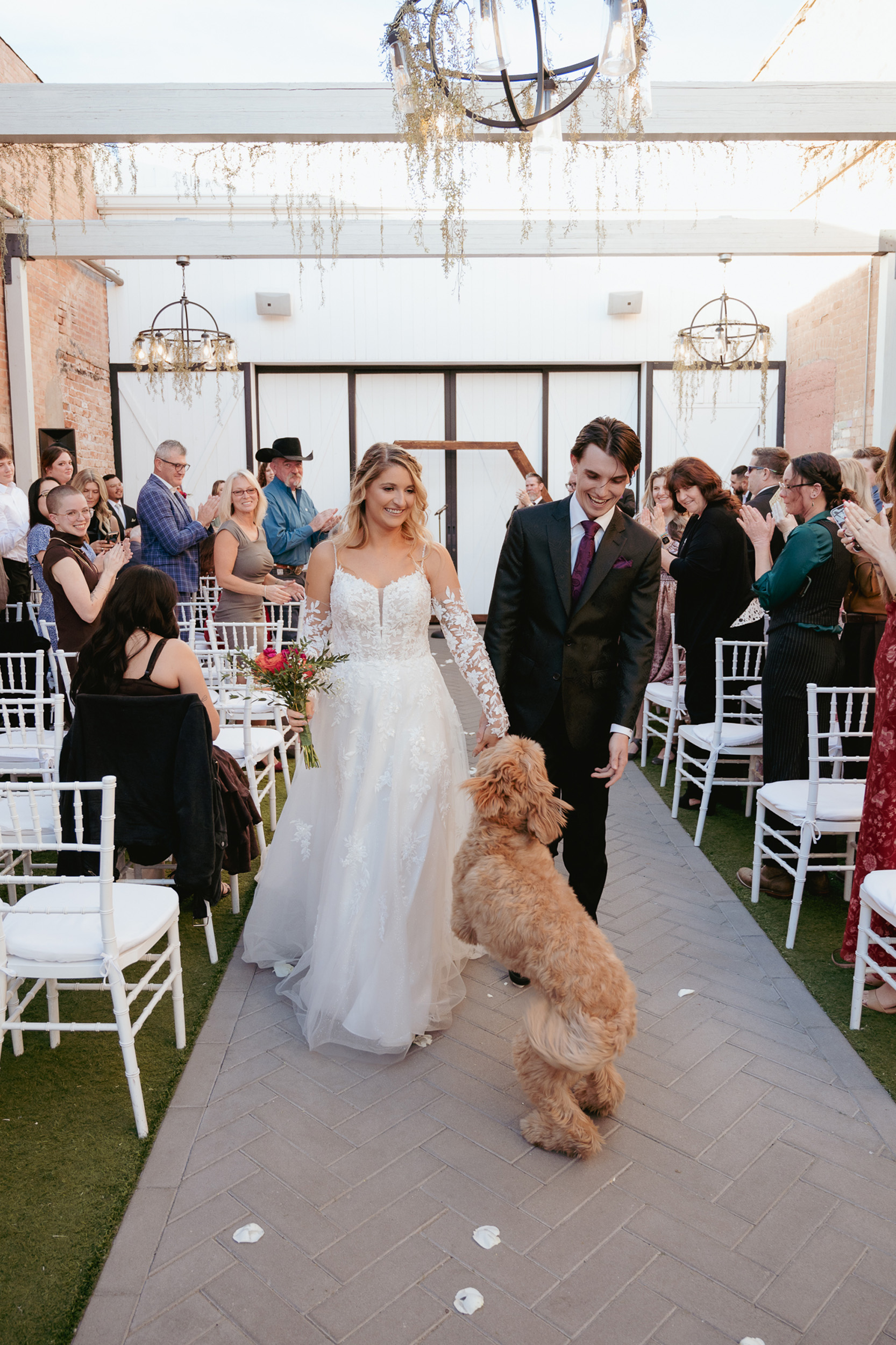 bride, groom and dog walking up aisle after wedding ceremony at Tre Bella Wedgewood Mesa Arizona.