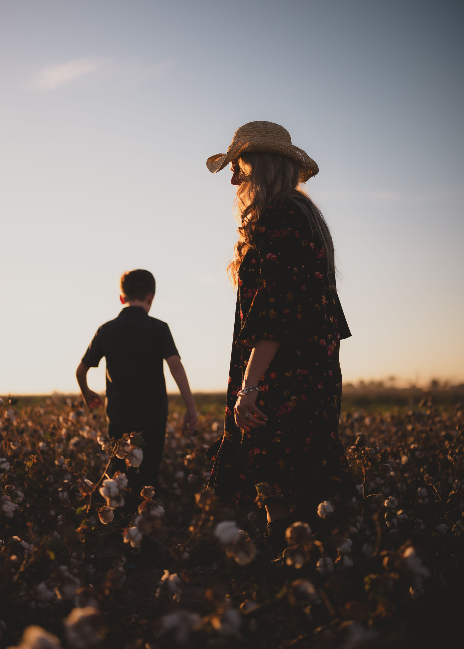 Mother and son walking through cotton field in Buckeye Arizona.