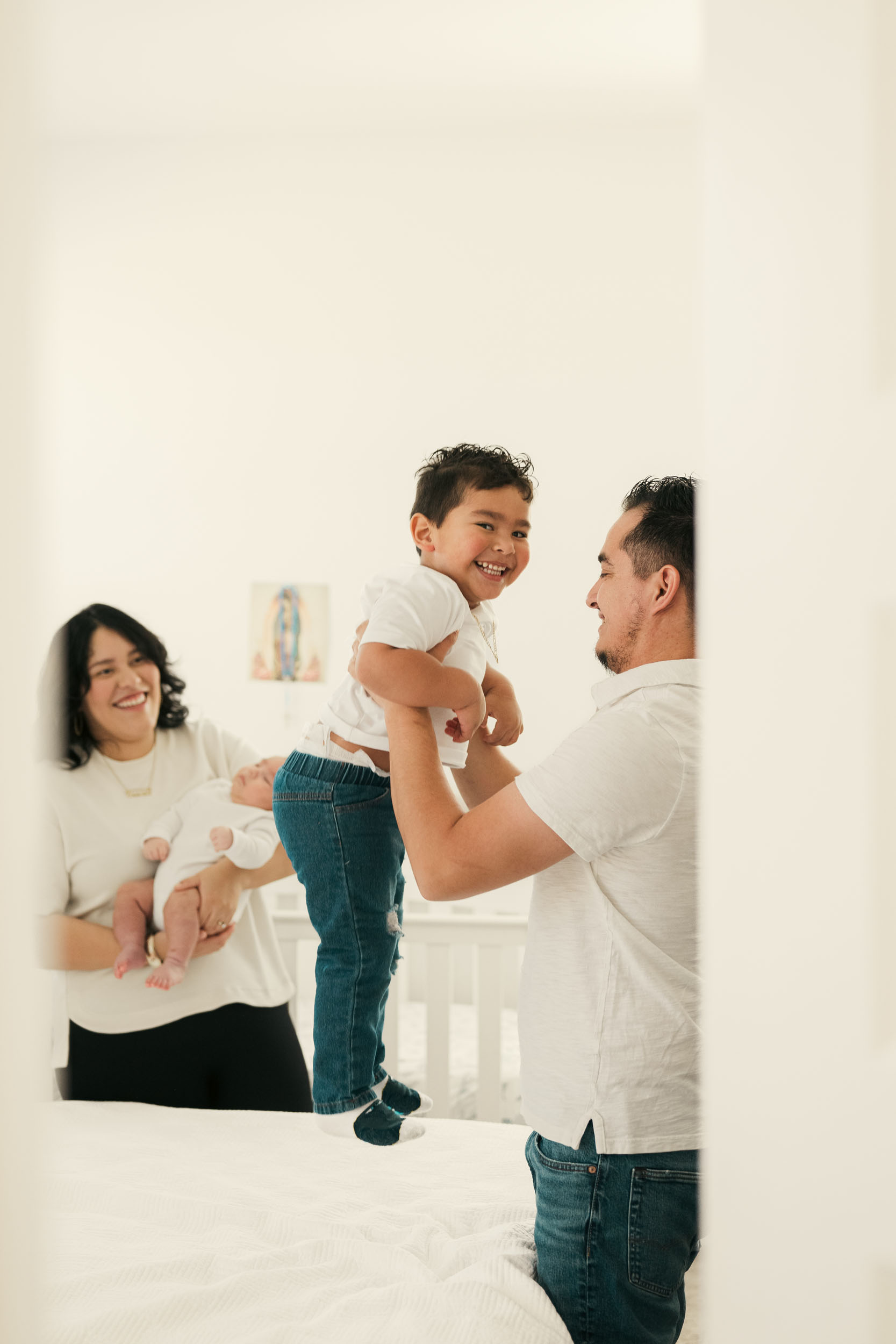 parents at home holding and playing with their children during lifestyle photo session in Avondale, Arizona