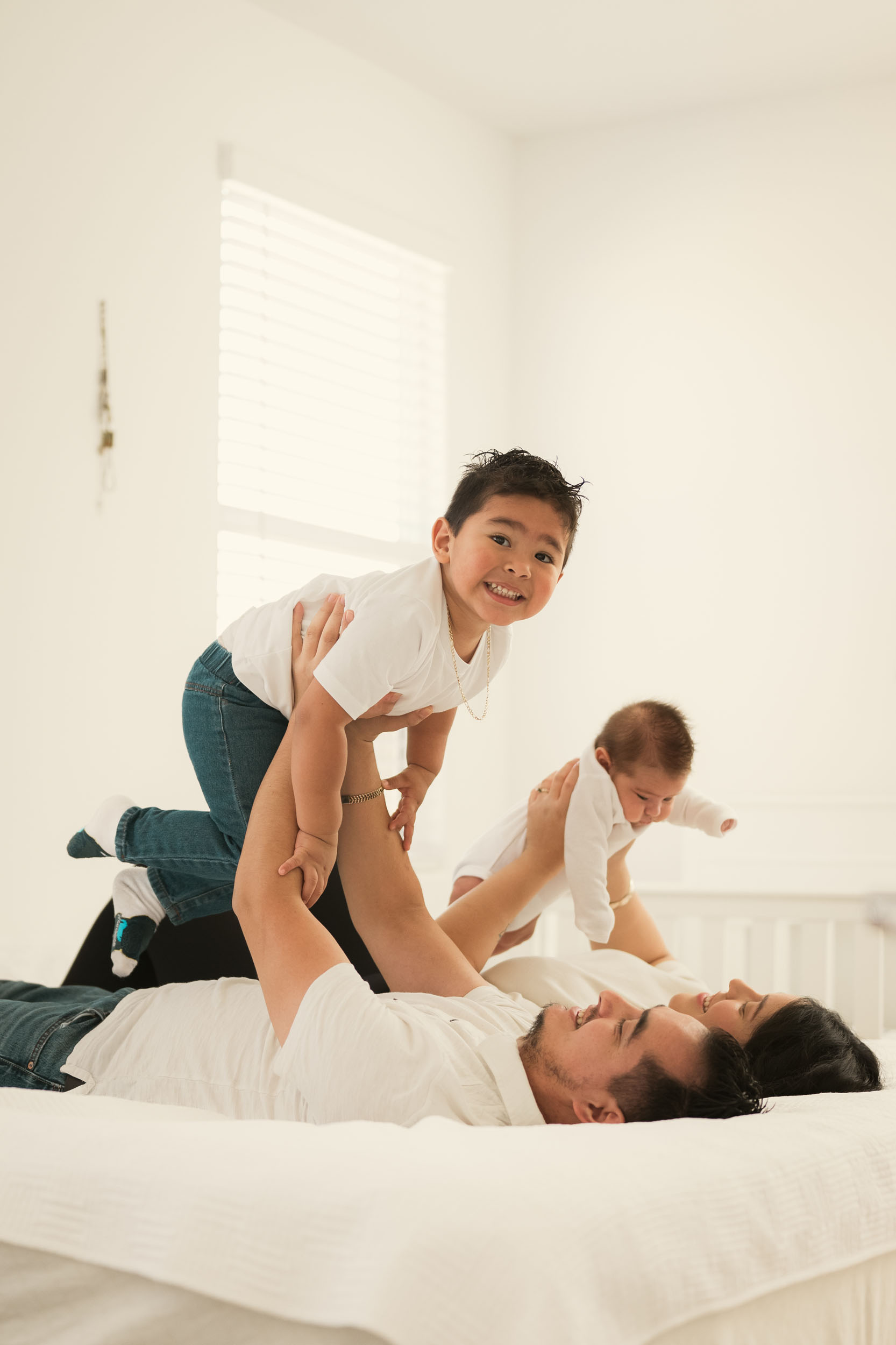 parents at home holding and playing with their children during lifestyle photo session in Avondale, Arizona