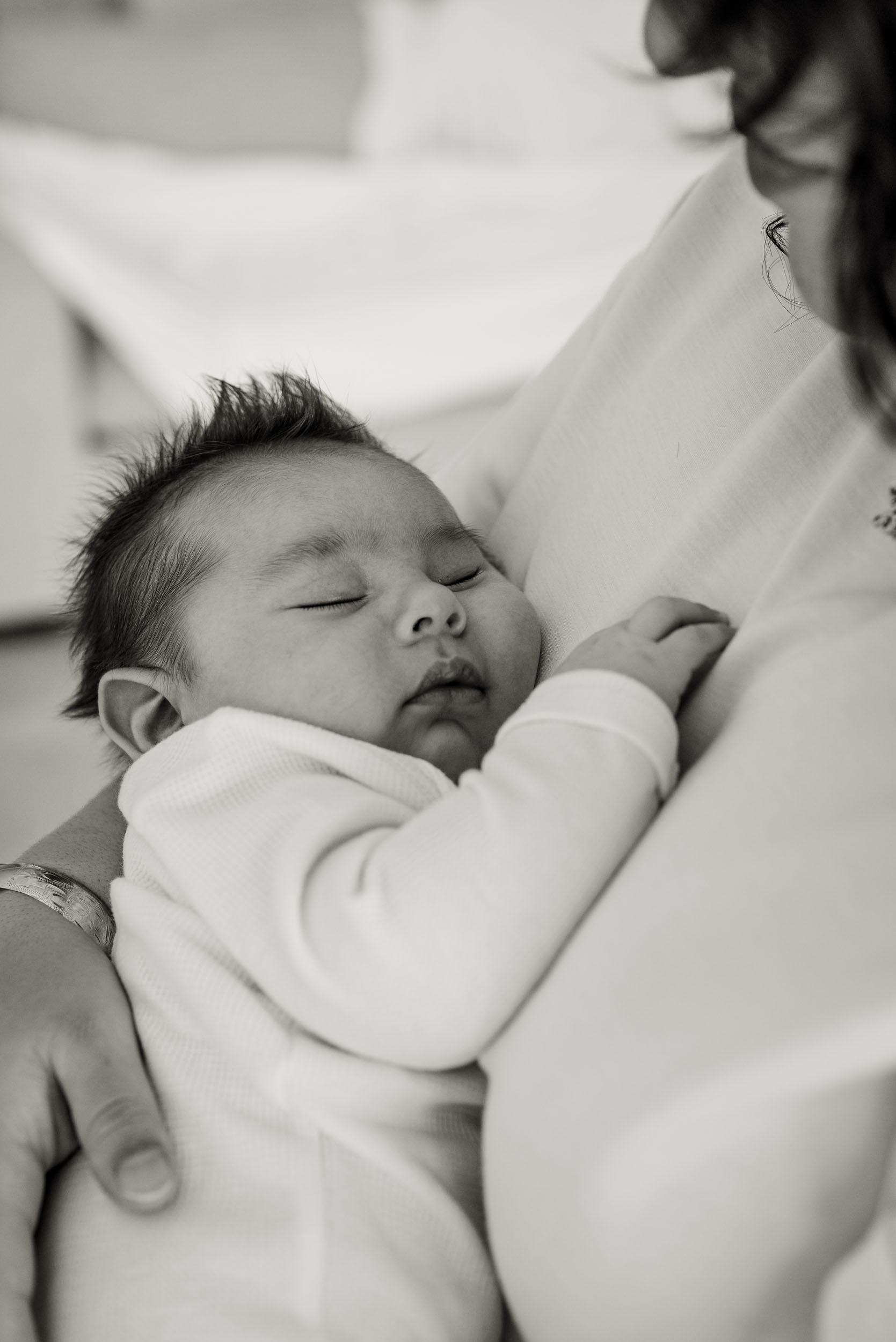 baby sleeping against mother's chest