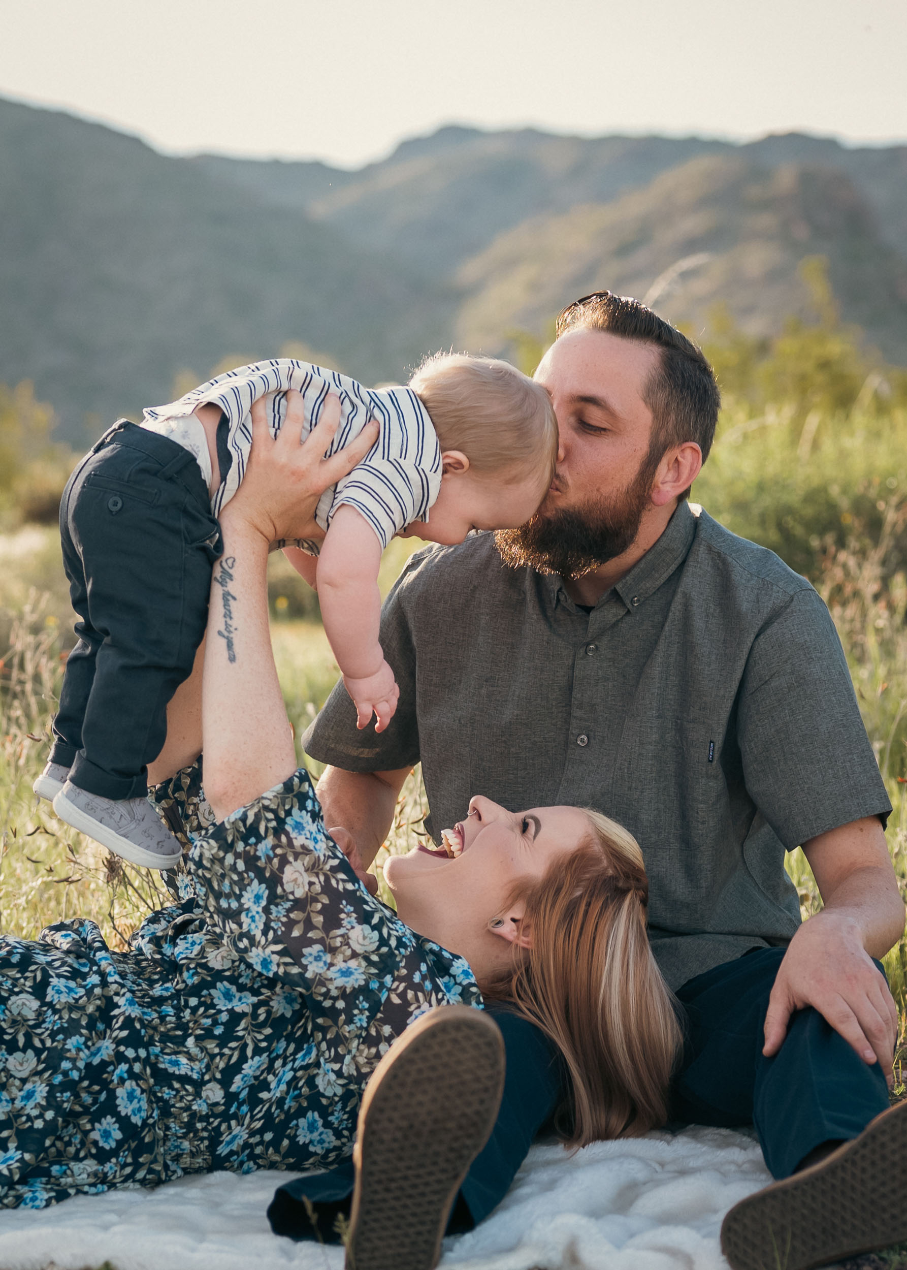 couple holding their baby playing and smiling at the White Tank Mountain Regional Park