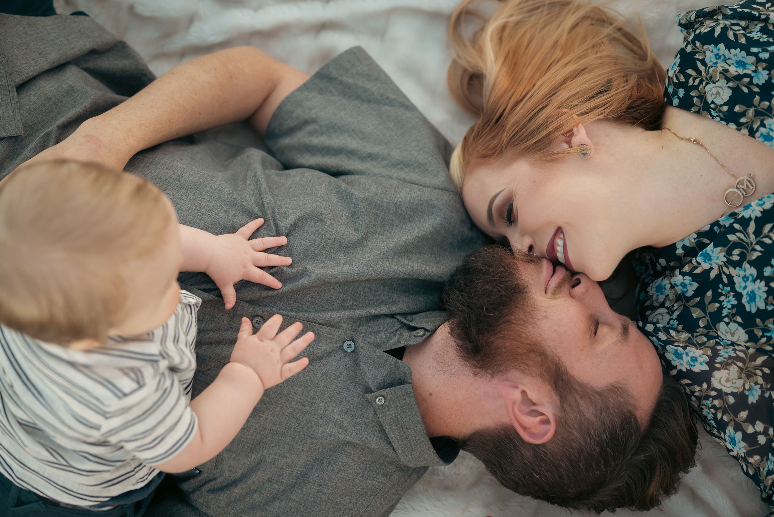 couple laying on blanket kissing