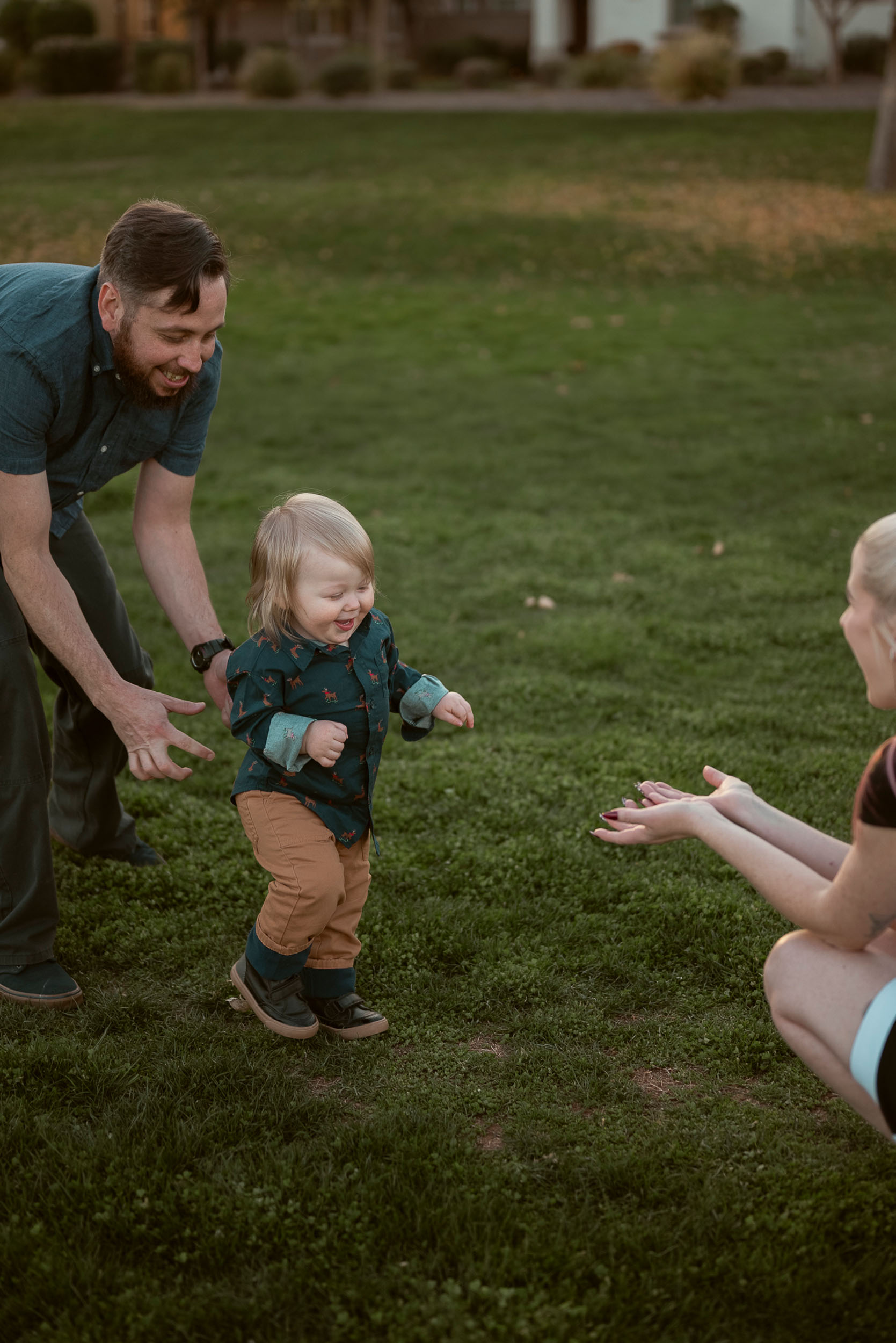 father and son running towards mother on a grassy field in Marley Park