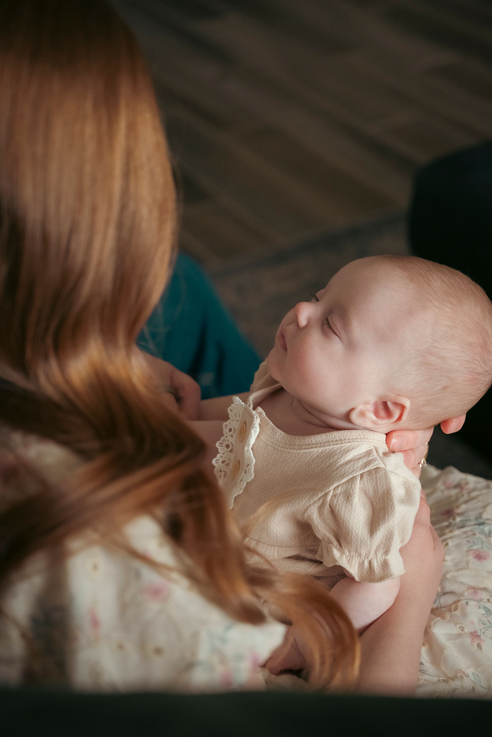 mother holding sleeping baby on lap
