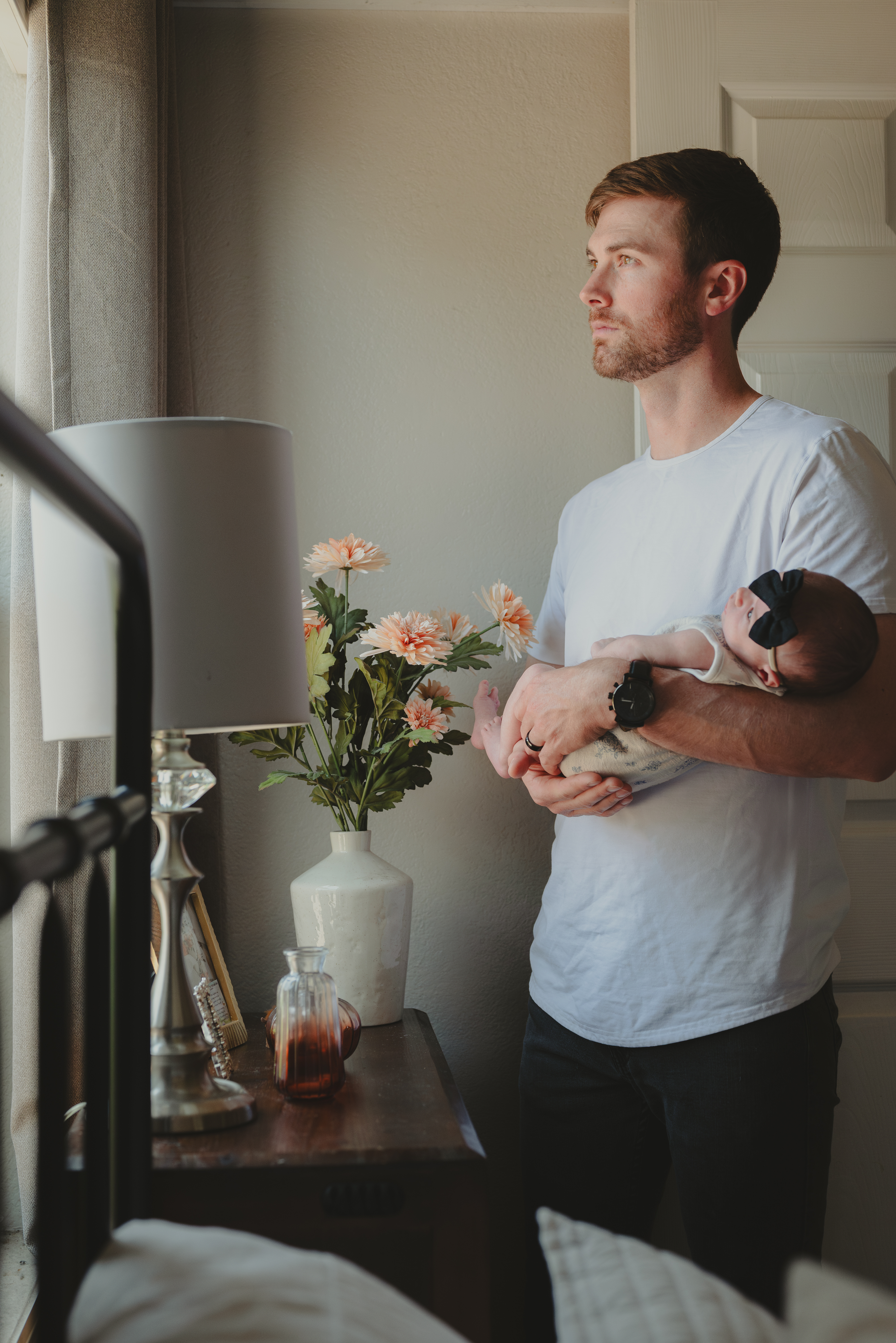 Newborn baby being held by father in Lifestyle Portrait.