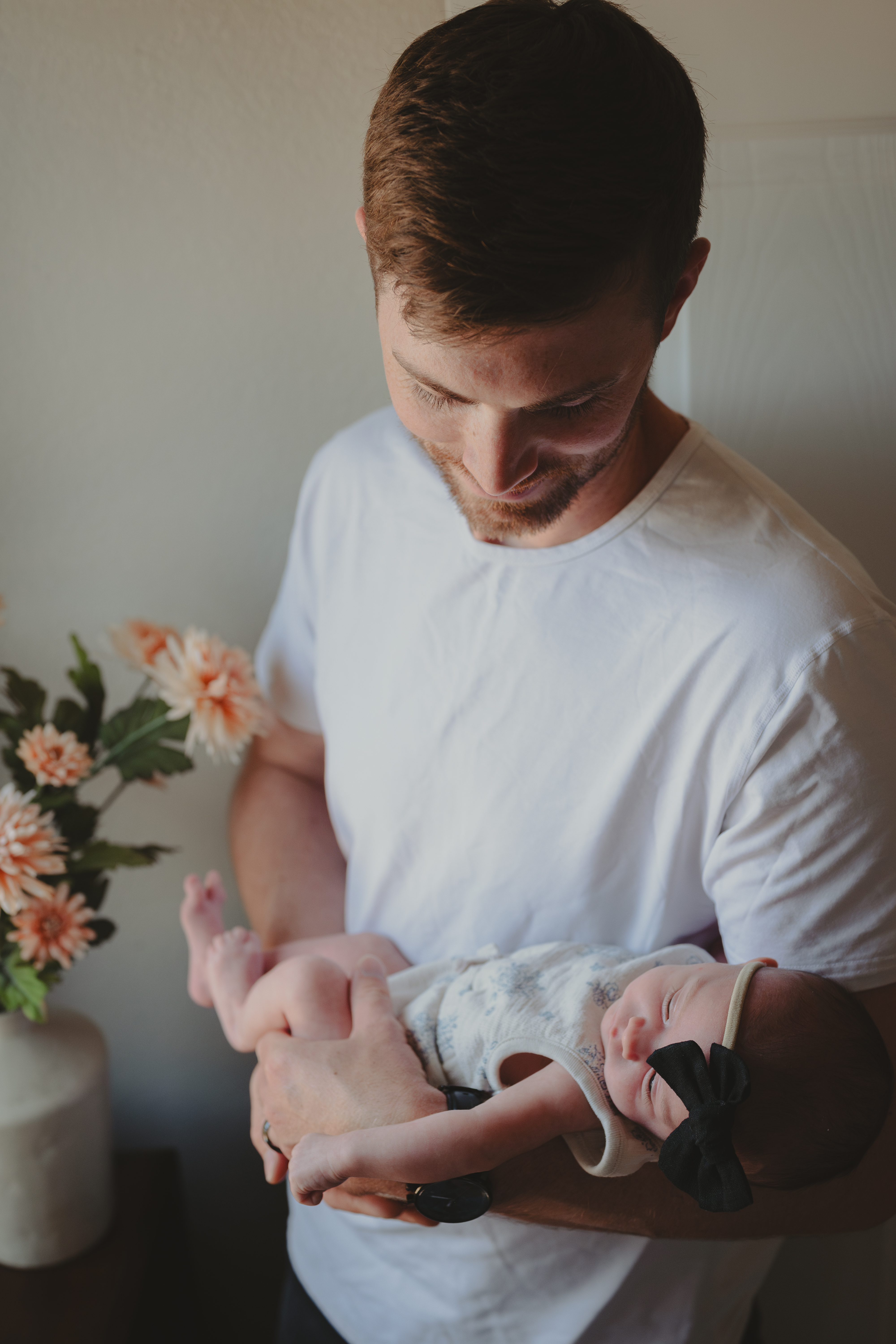 Newborn baby being held by father in Lifestyle Portrait.