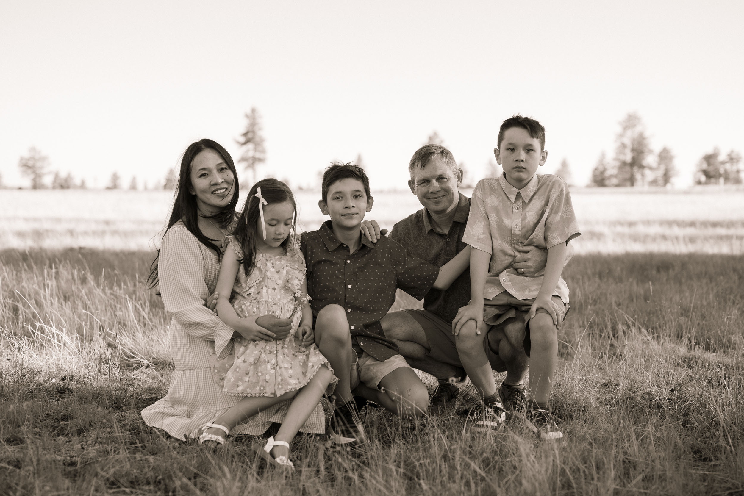 black and white photo of family sitting in grassy meadow in Northern Arizona