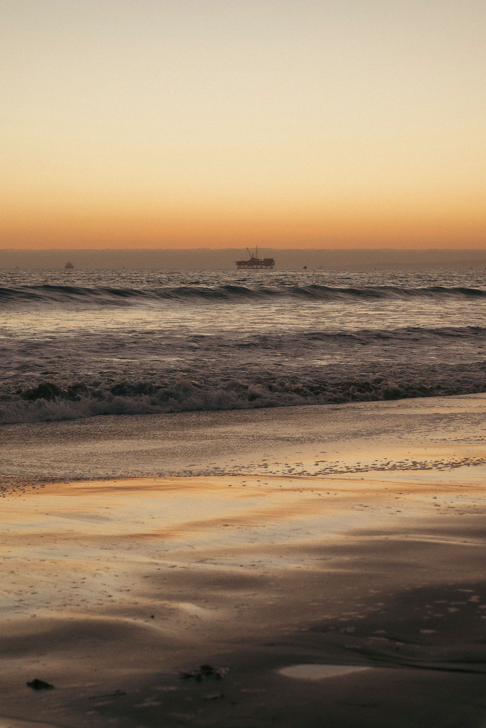 Golden sunset along the glistening shore of Sunset Beach, California.