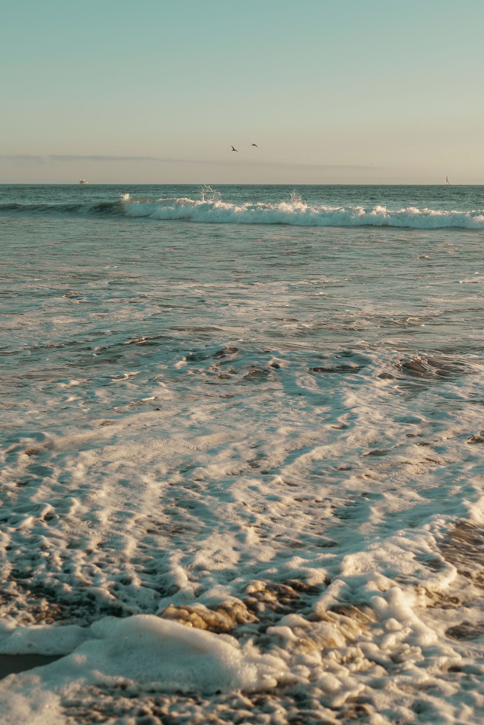 Tide rolling in along the shore of Sunset Beach, California.
