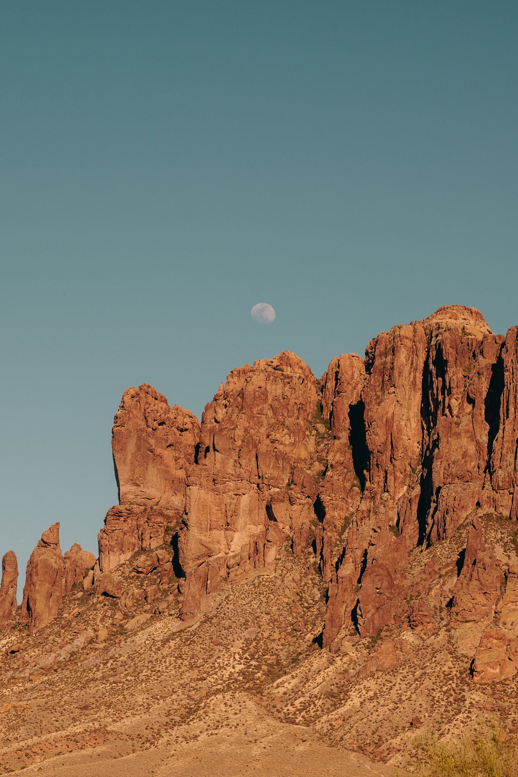 Superstition mountains with moon rising above, in Apache Junction, Arizona.