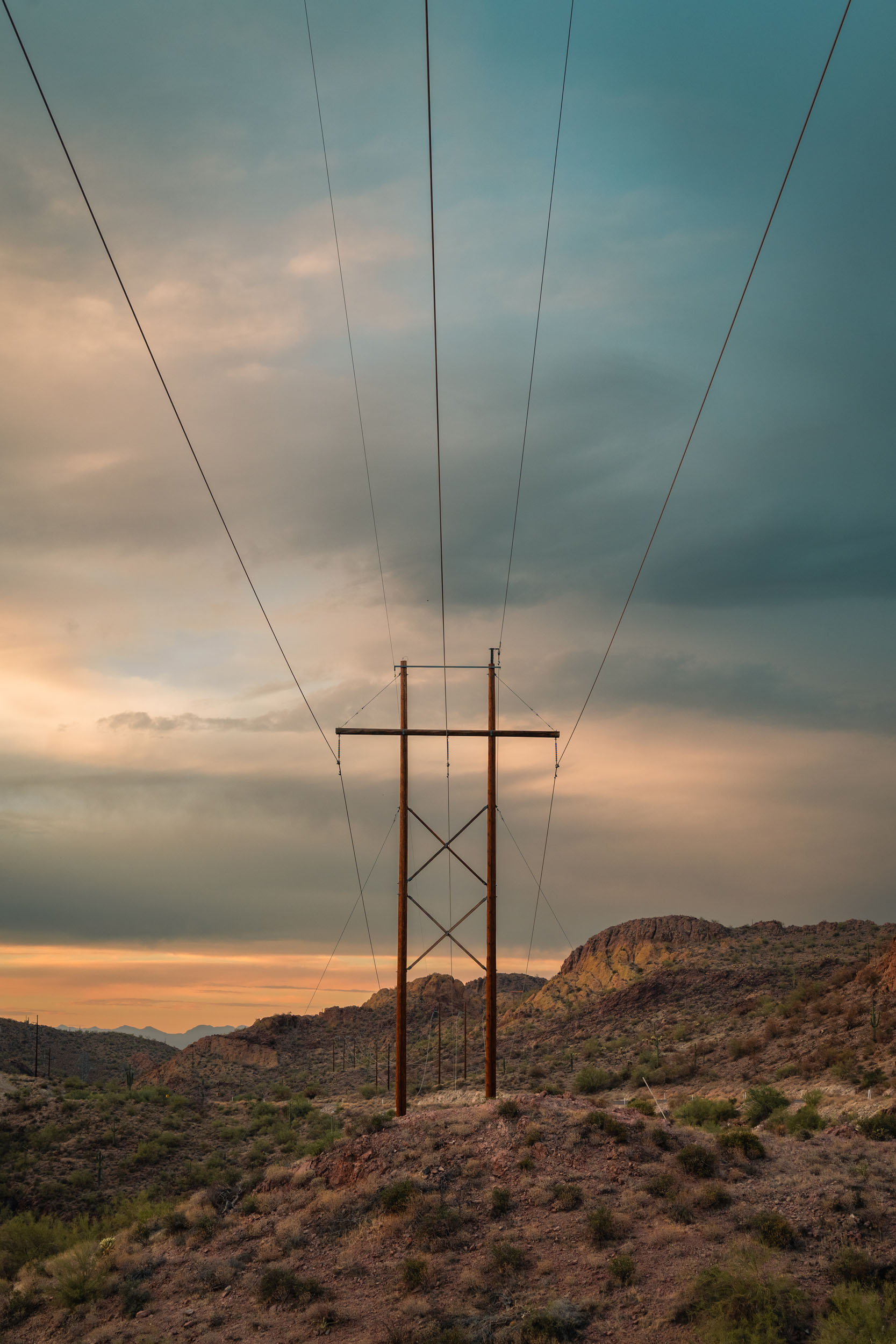 Man altered landscape with powerlines spanning through the hillsides of the Apache Trail in Arizona.