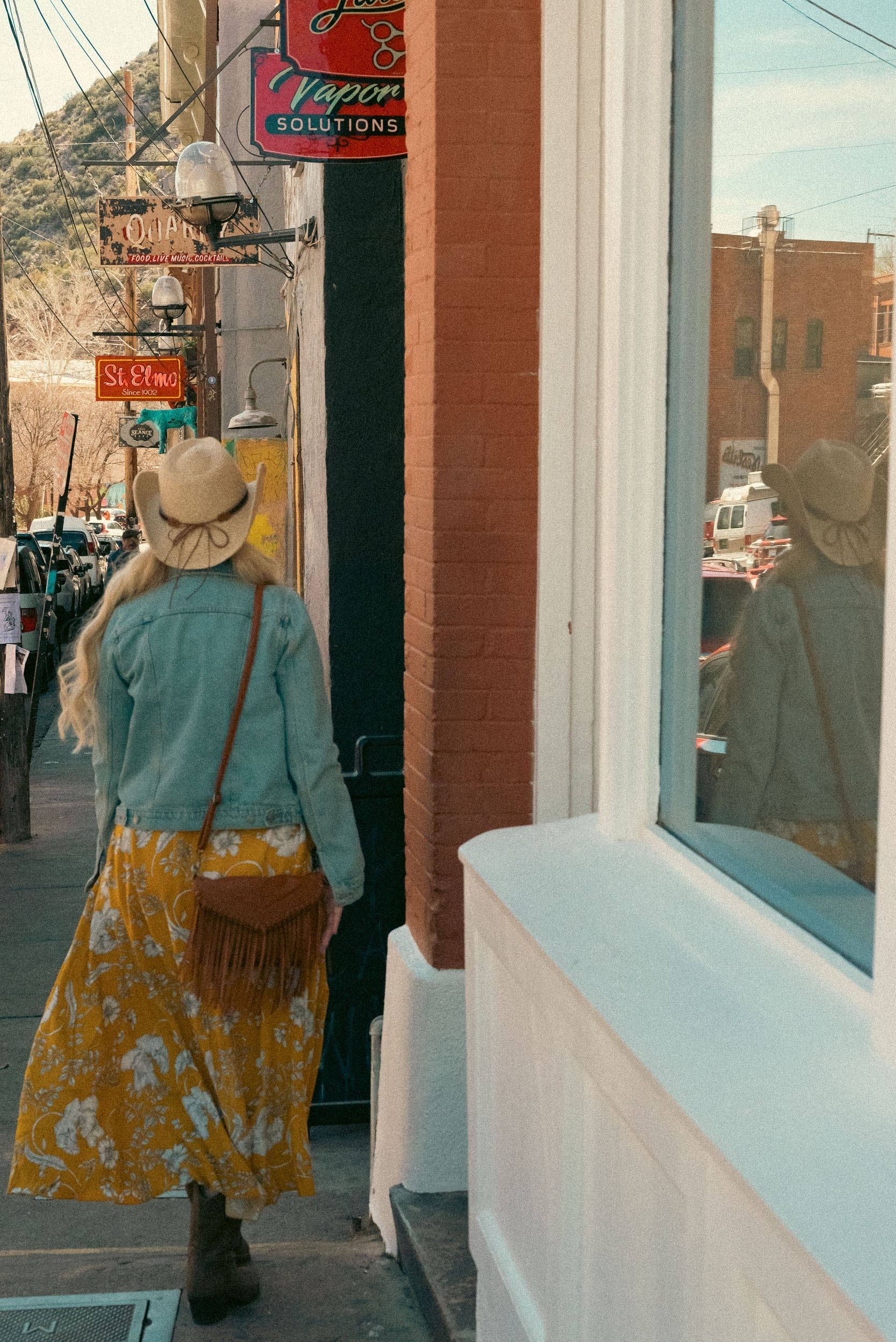 woman walking in old town Bisbee Arizona with reflection in the glass