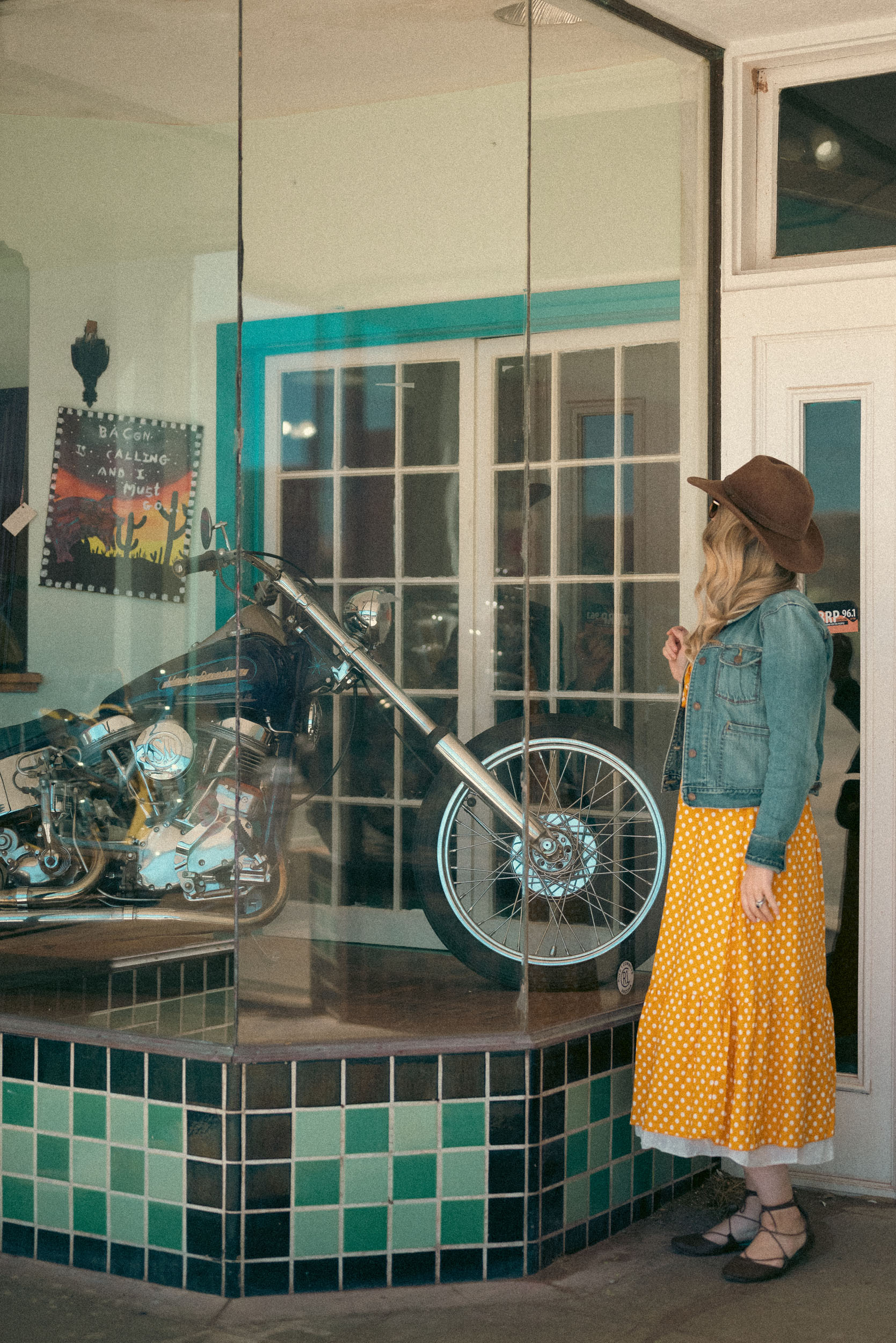 a woman looking into a shop display of a motorcycle in Bisbee Lowell Arizona