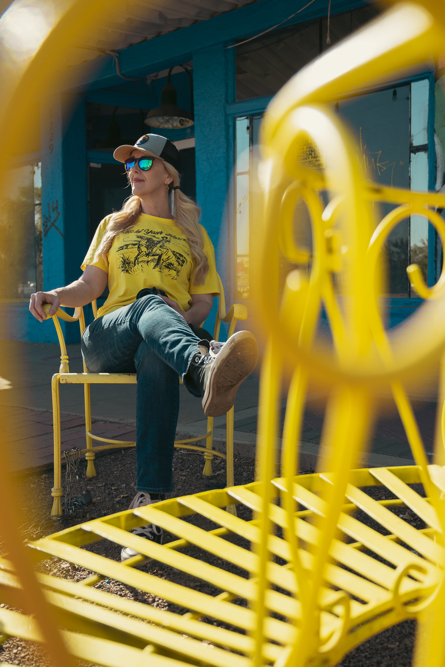 Woman sitting on yellow chair on Historic Grand Avenue Phoenix Arizona.