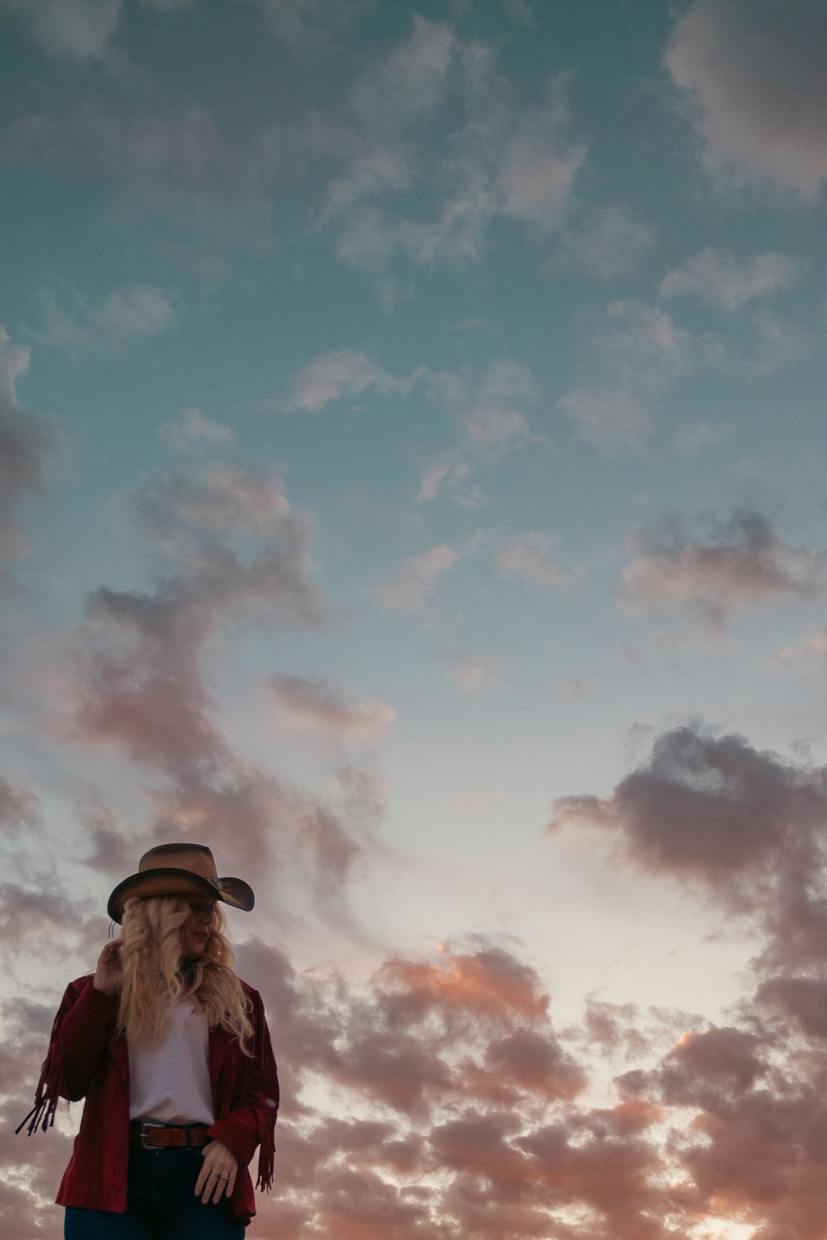 Colorful sky at sunset with cowgirl.