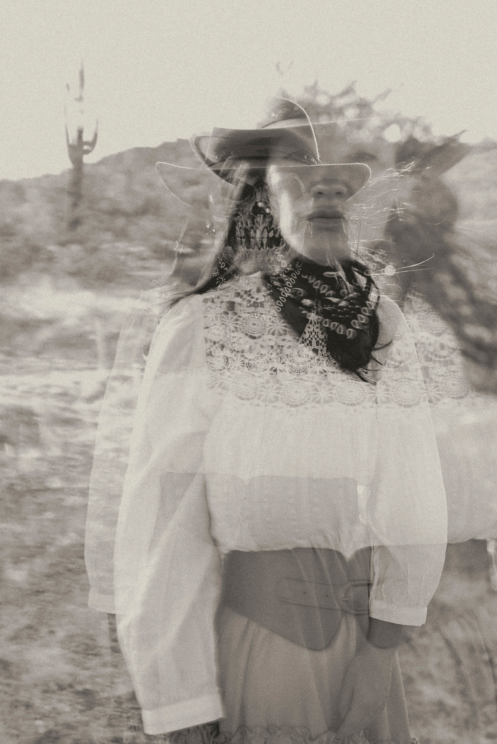 Ghostly double exposure image of woman and skeleton in a western desert landscape.